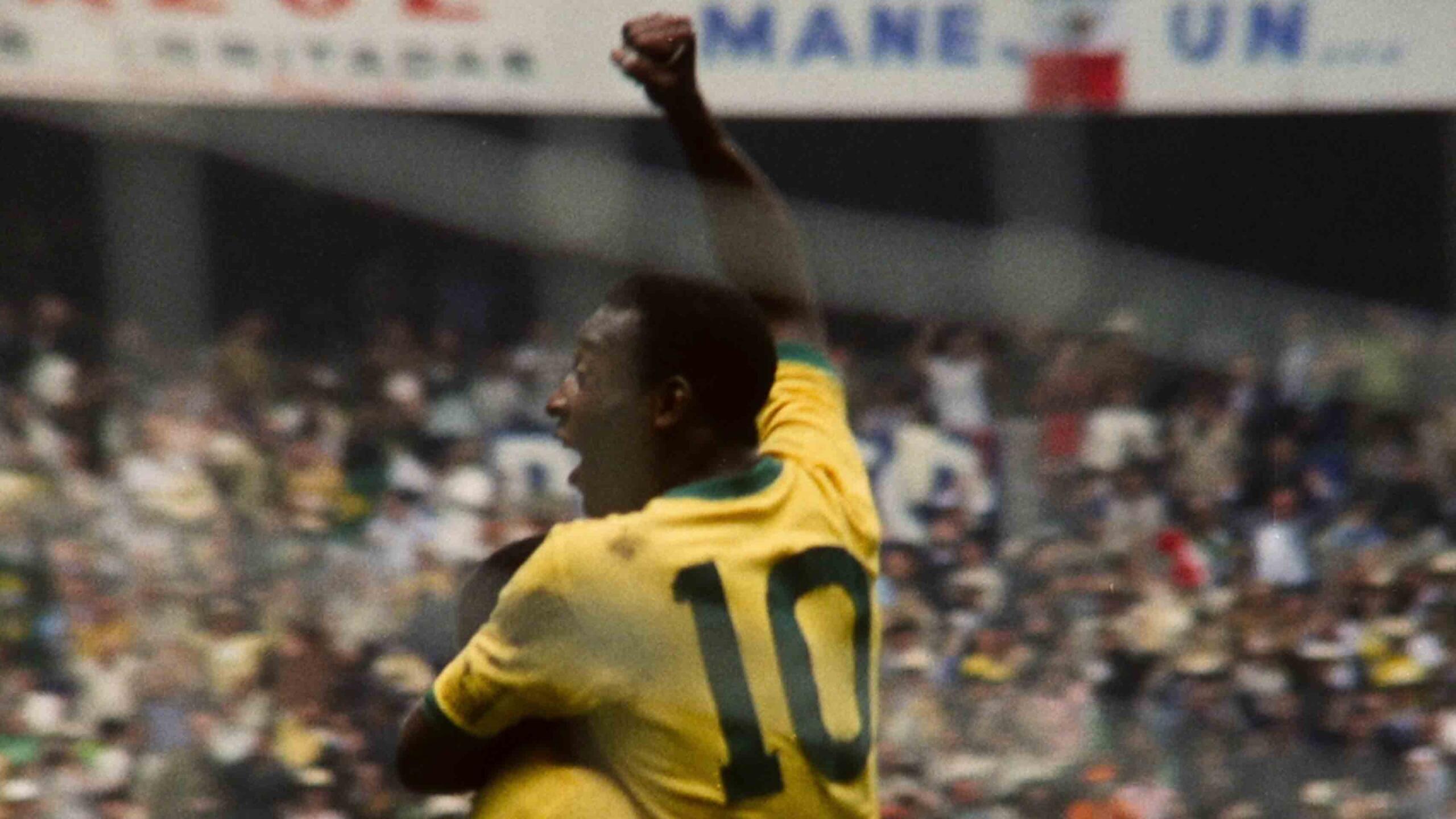 Pelé comemorando um gol, com o estádio lotado de torcedores, na Copa do Mundo.
