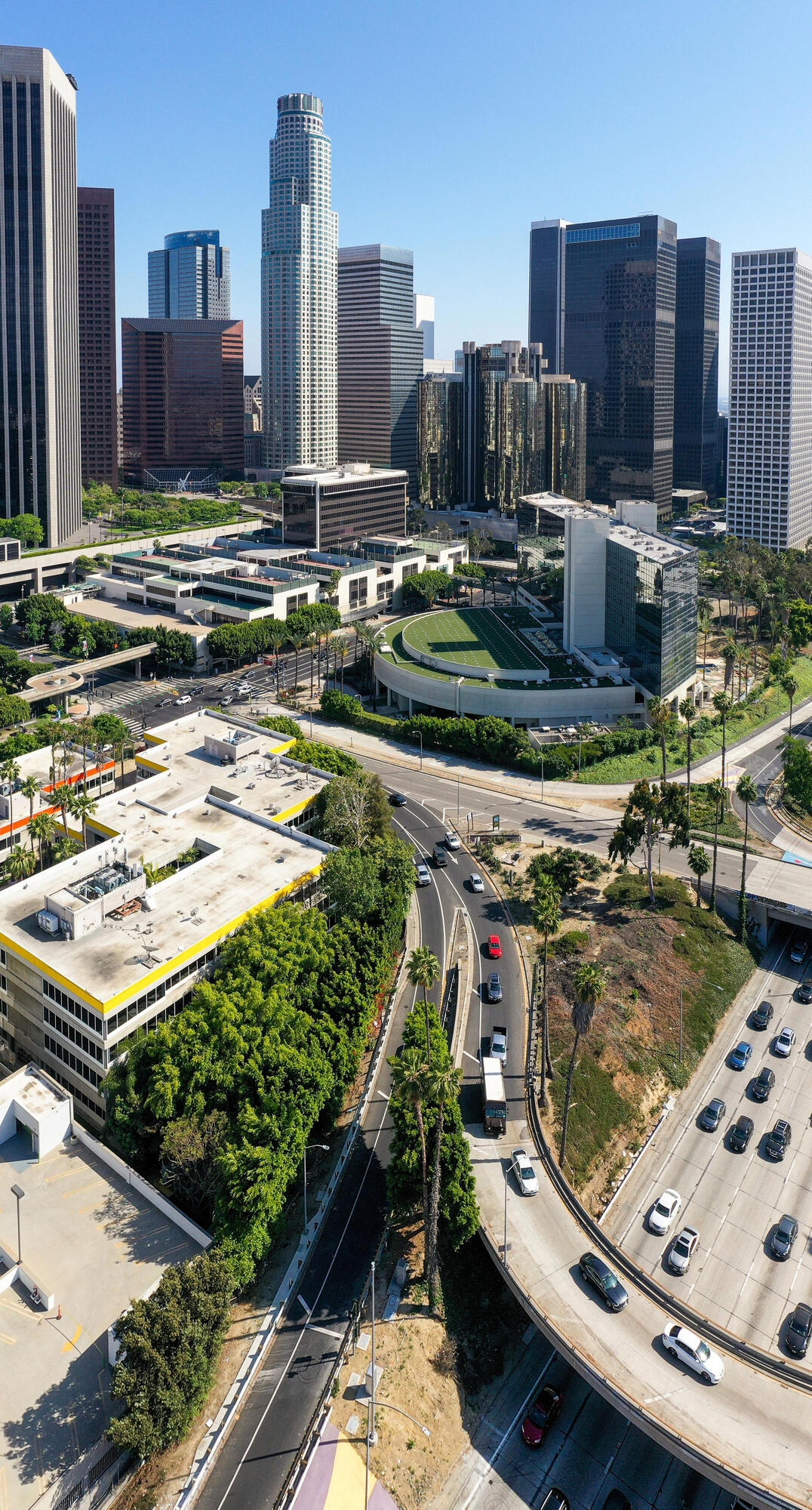 Cidade com ruas, edifícios e área verde vista de cima. 