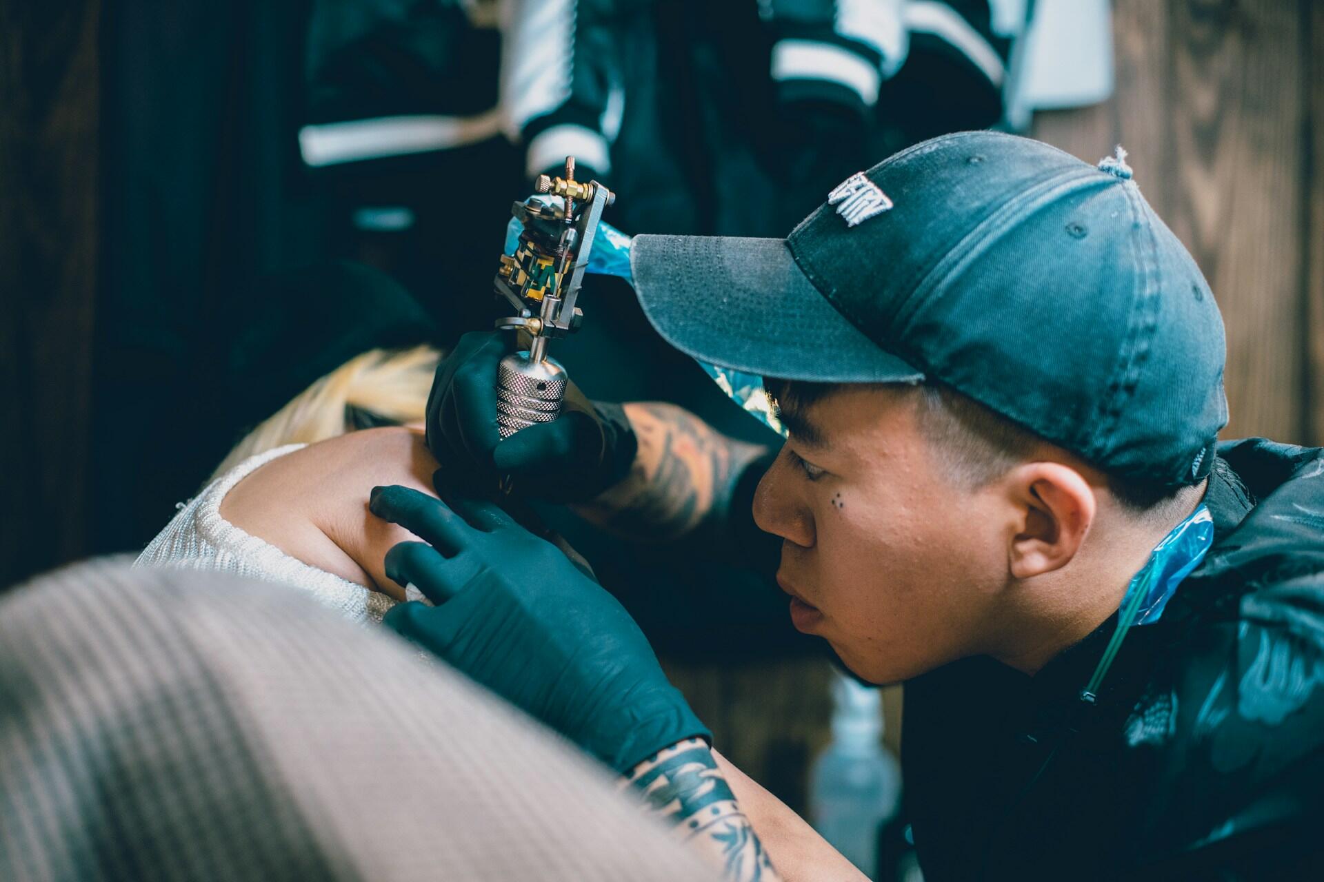 Tatuador usando uma máquina de tatuagem.