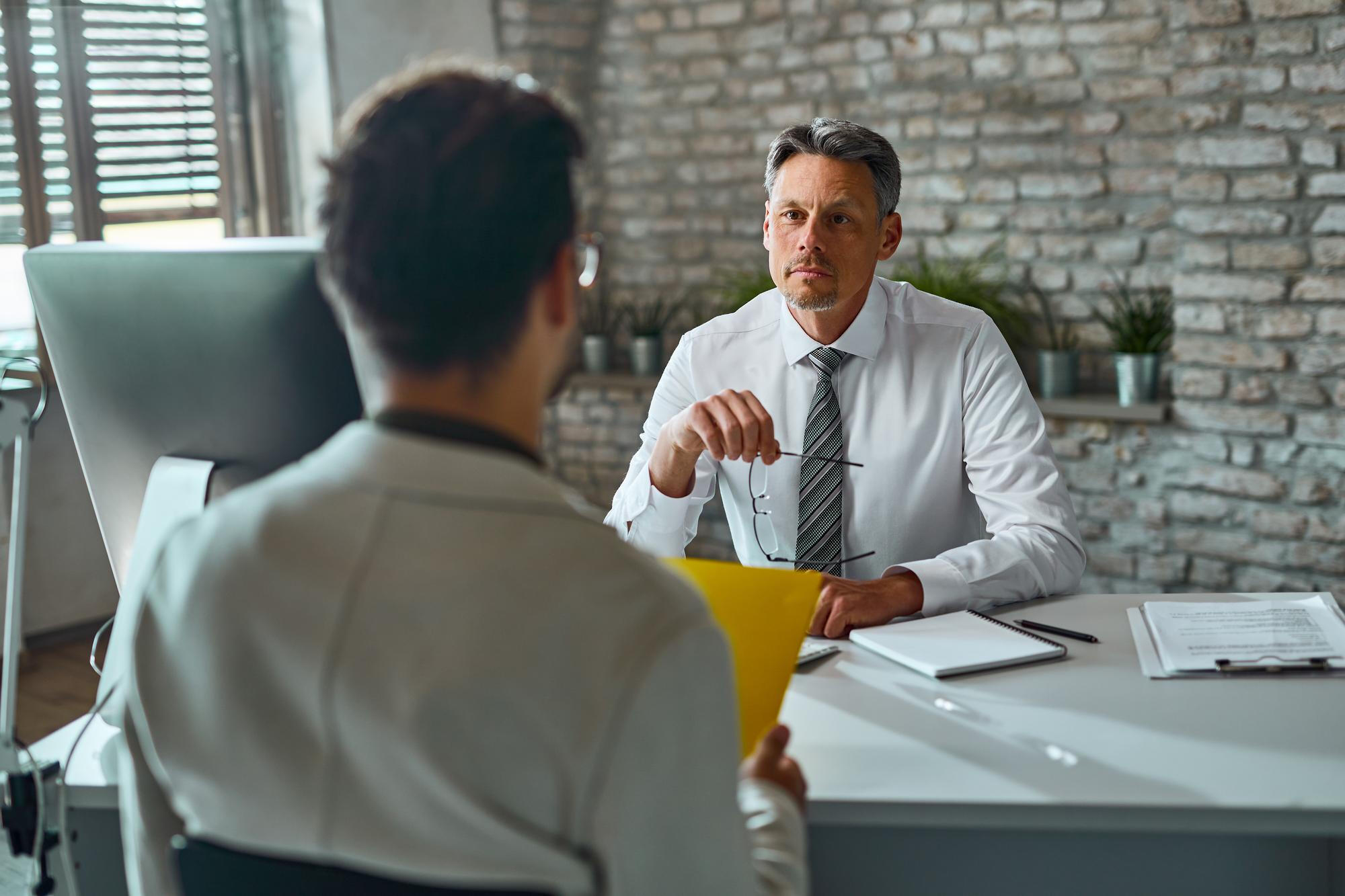 Profissional em entrevista de emprego com profissional de RH.