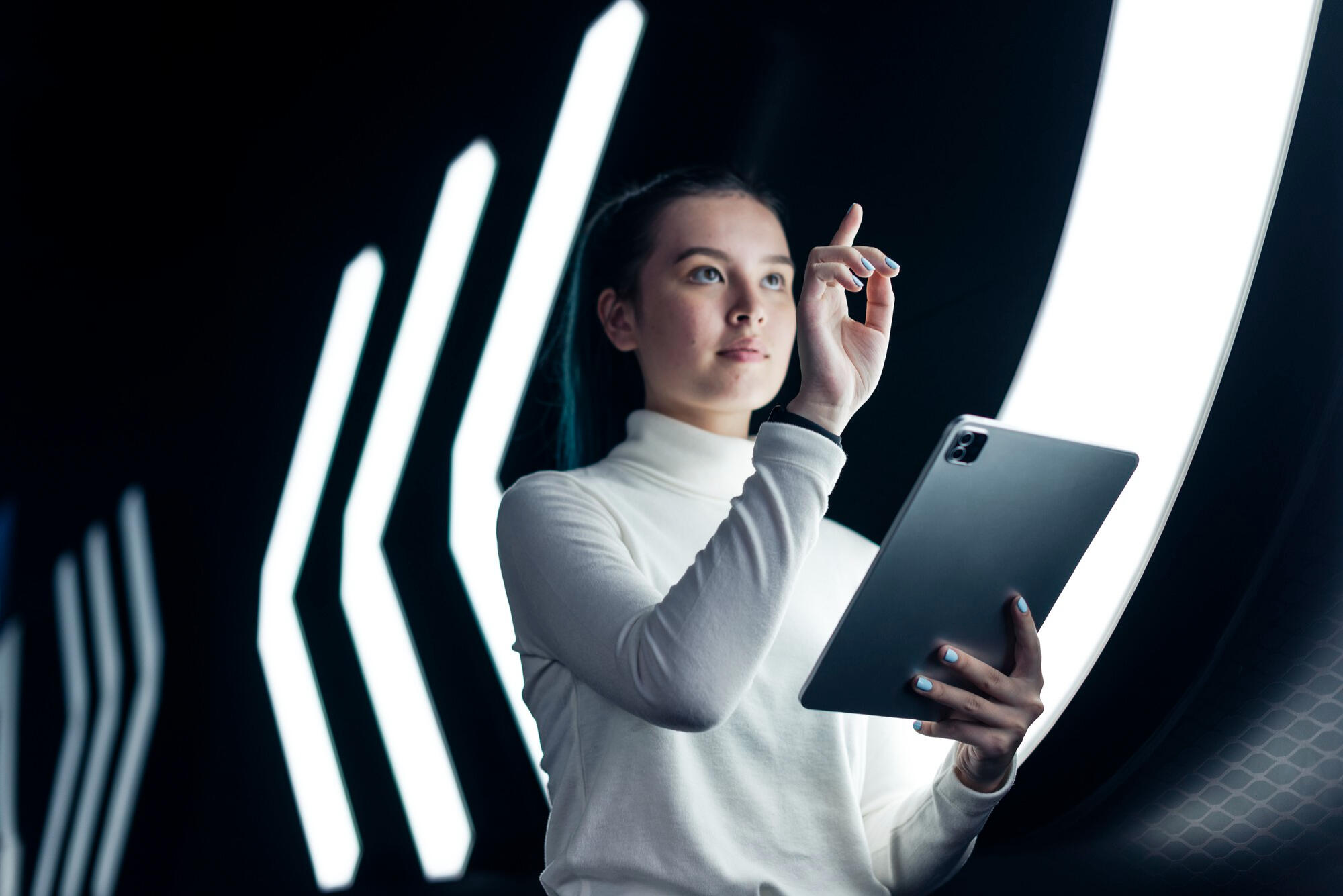 Profissional do futuro com tablet na mão e apontando para cima.