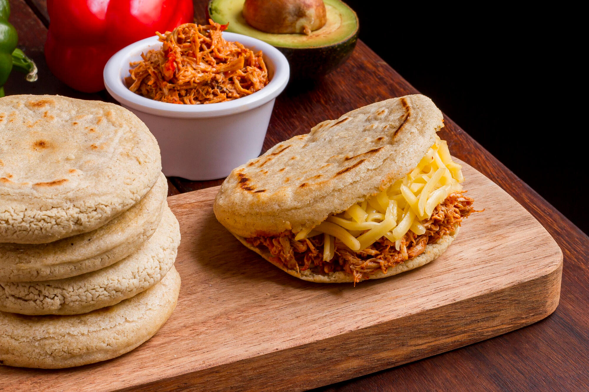 Arepa colombiana com recheio em cima da tábua.