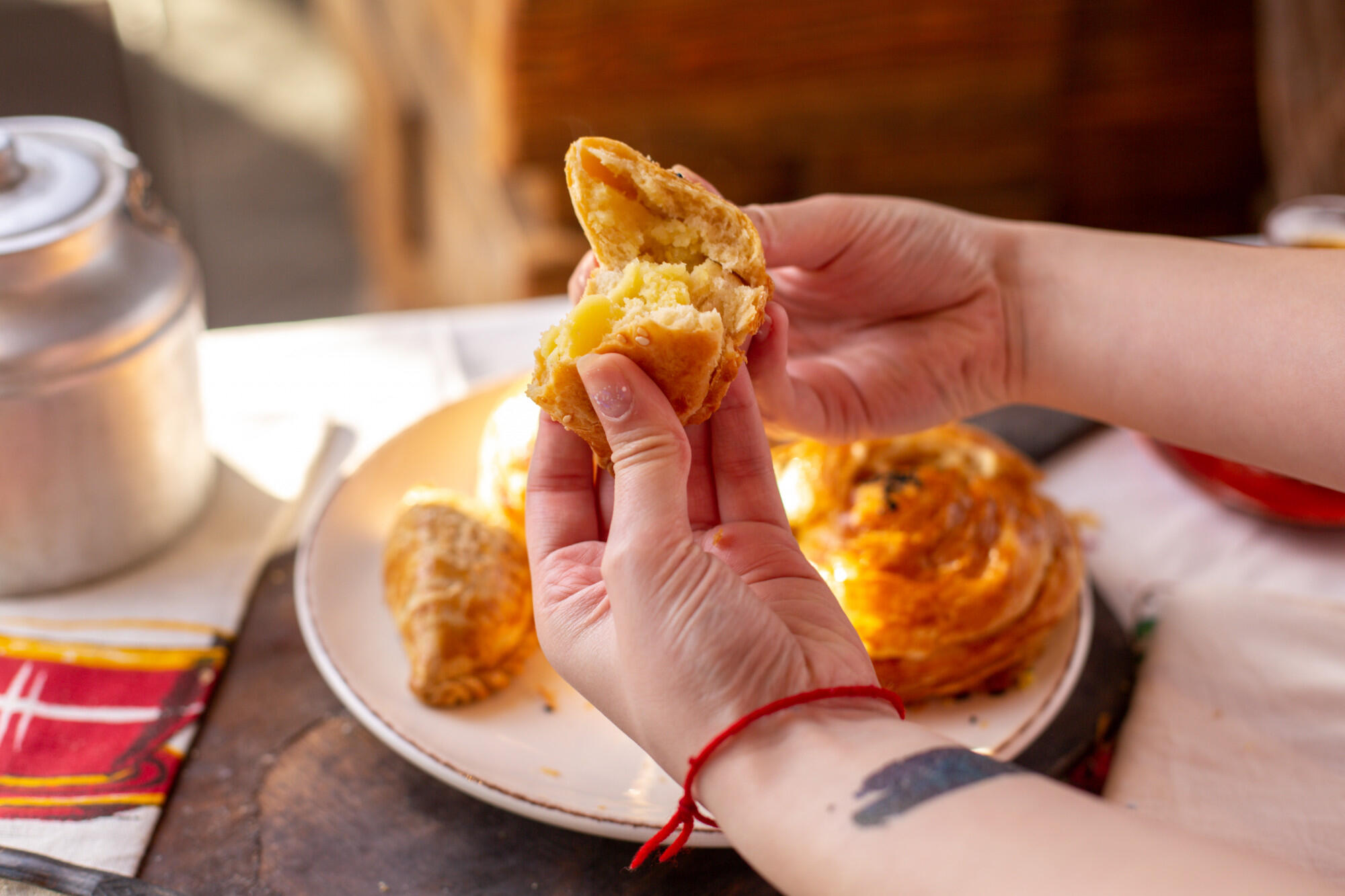 Mão abrindo a empanada chilena. 