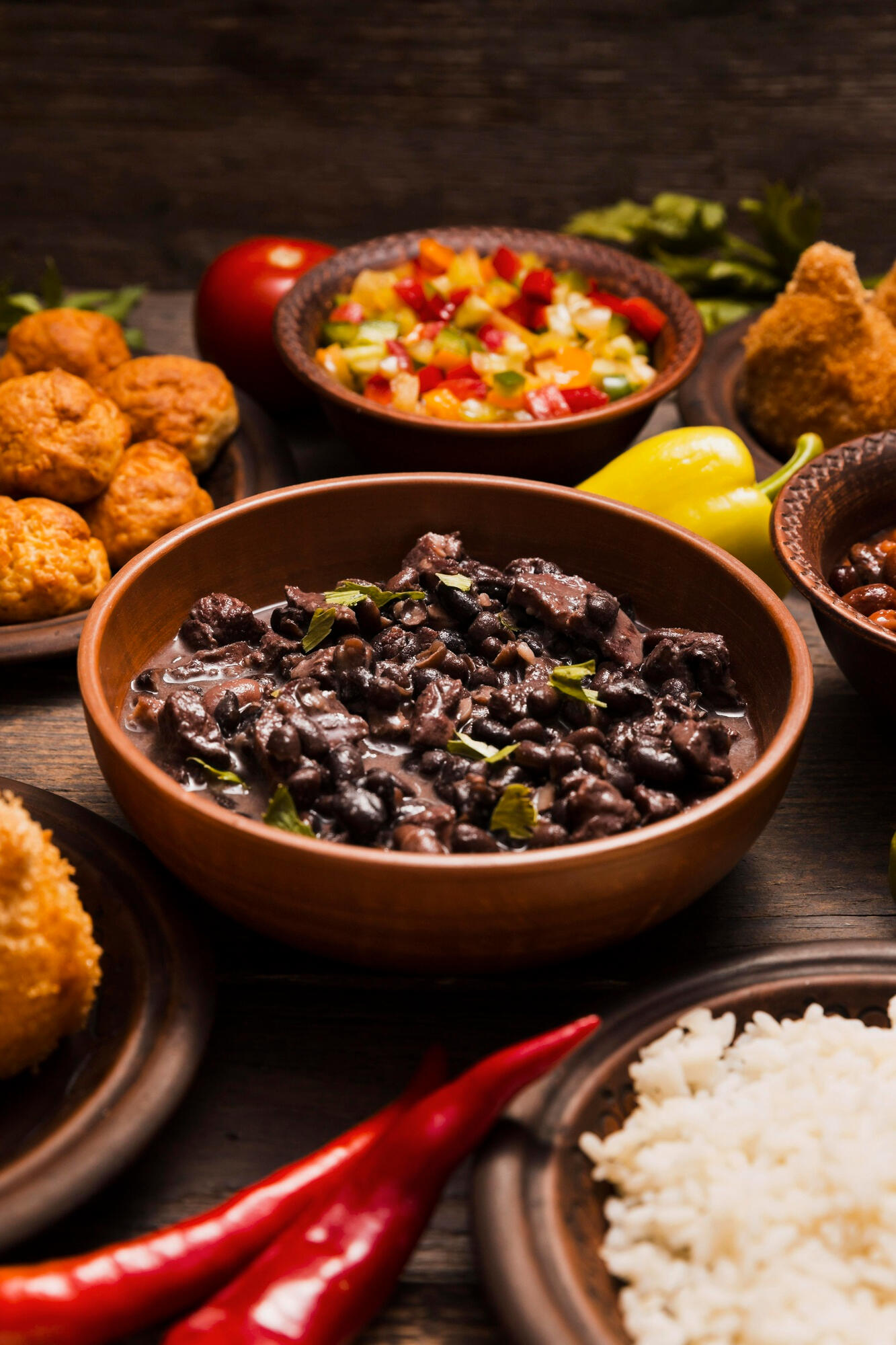 Feijoada e outros ingredientes em tigelas. 