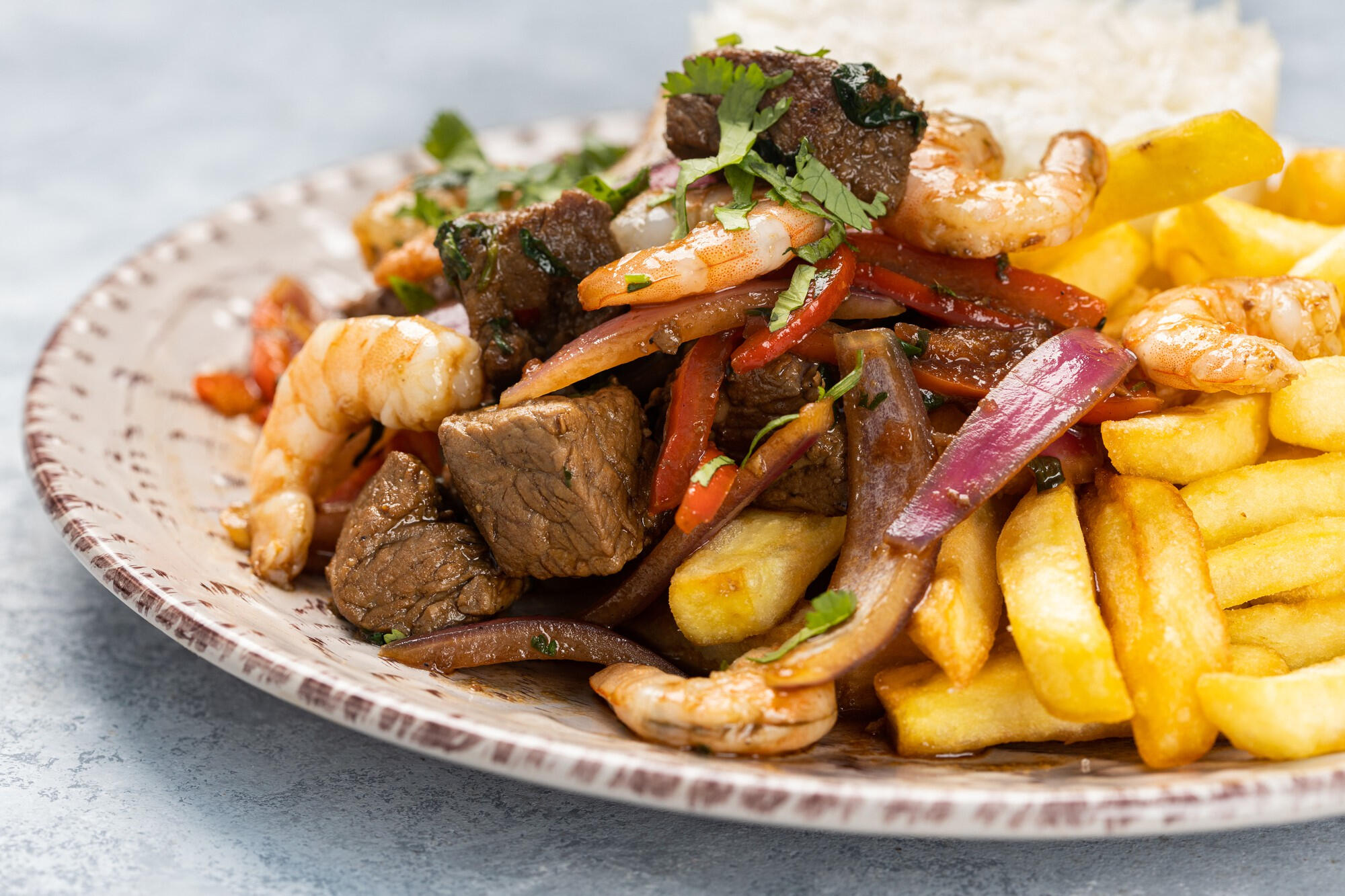 Prato de lomo saltado em cima da mesa. 
