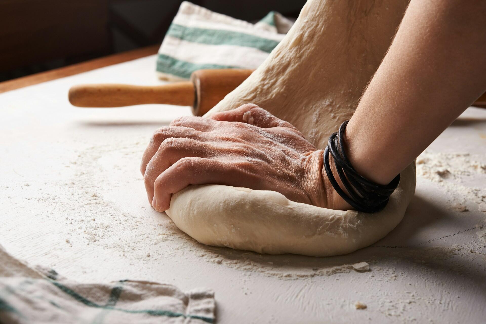 Imagem de mãos sovando uma massa