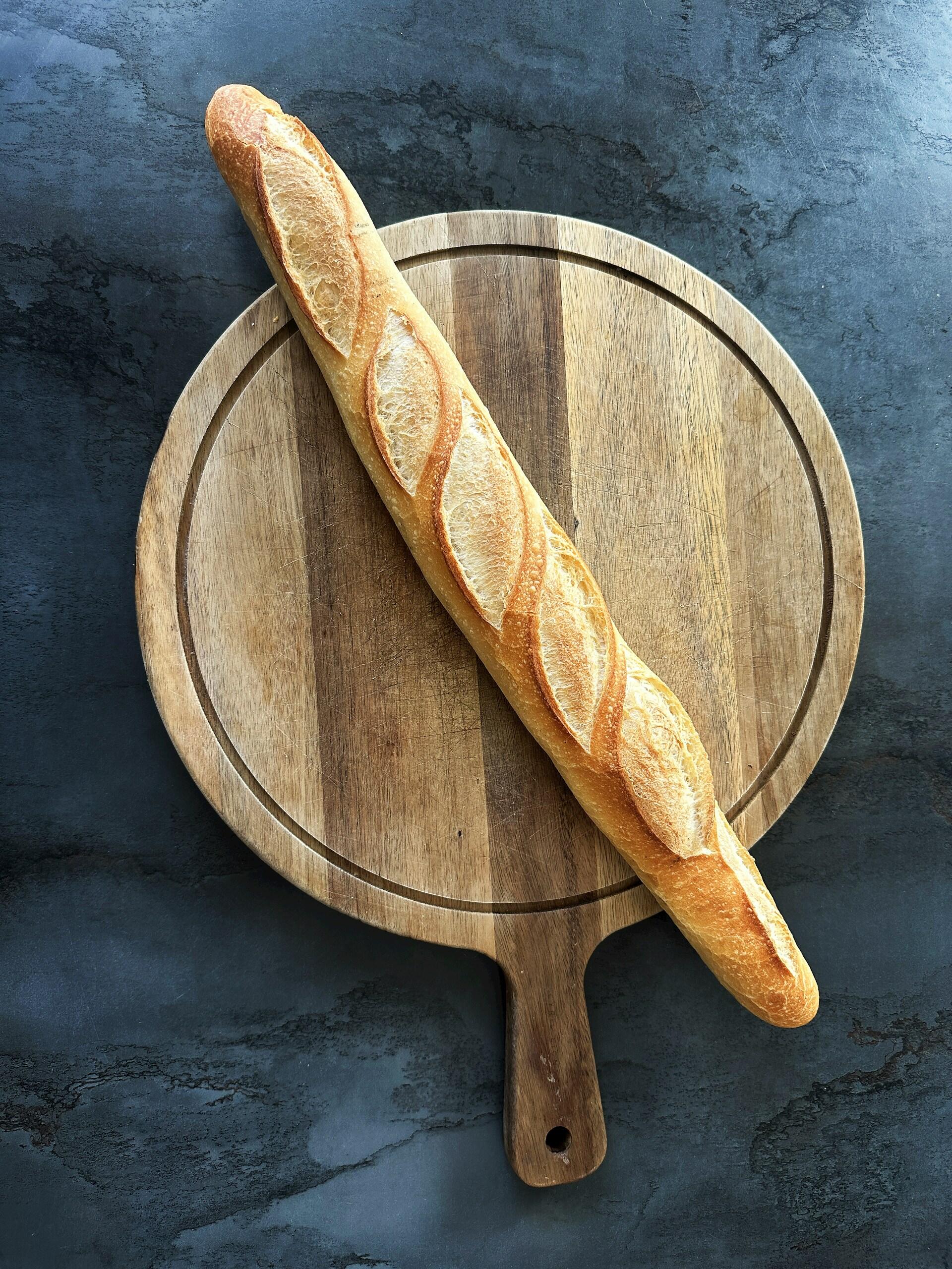 Imagem de uma baguete em uma tábua.