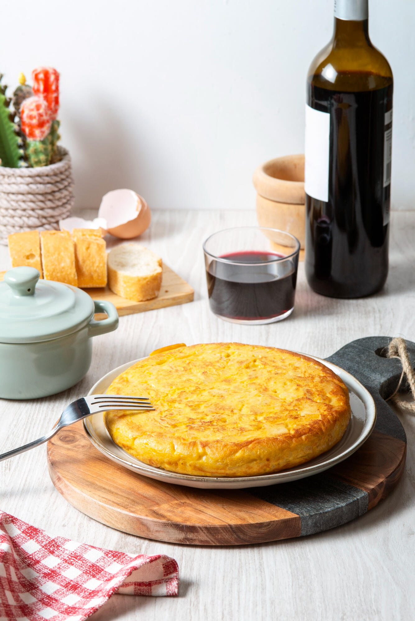 Pastel de choclo em cima da mesa, com bebida e copo. 