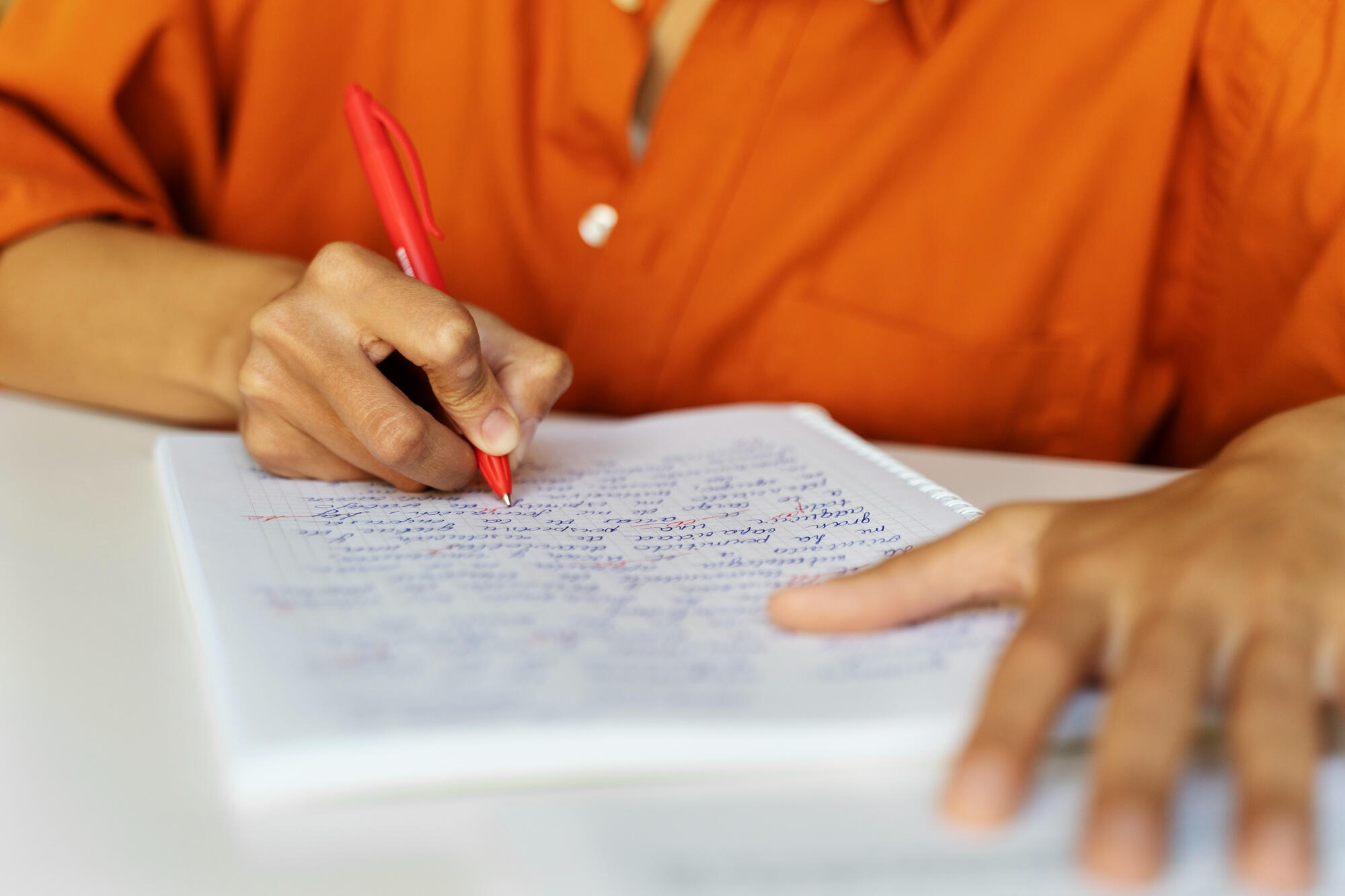 Mulher escrevendo texto com caneta na folha de papel.