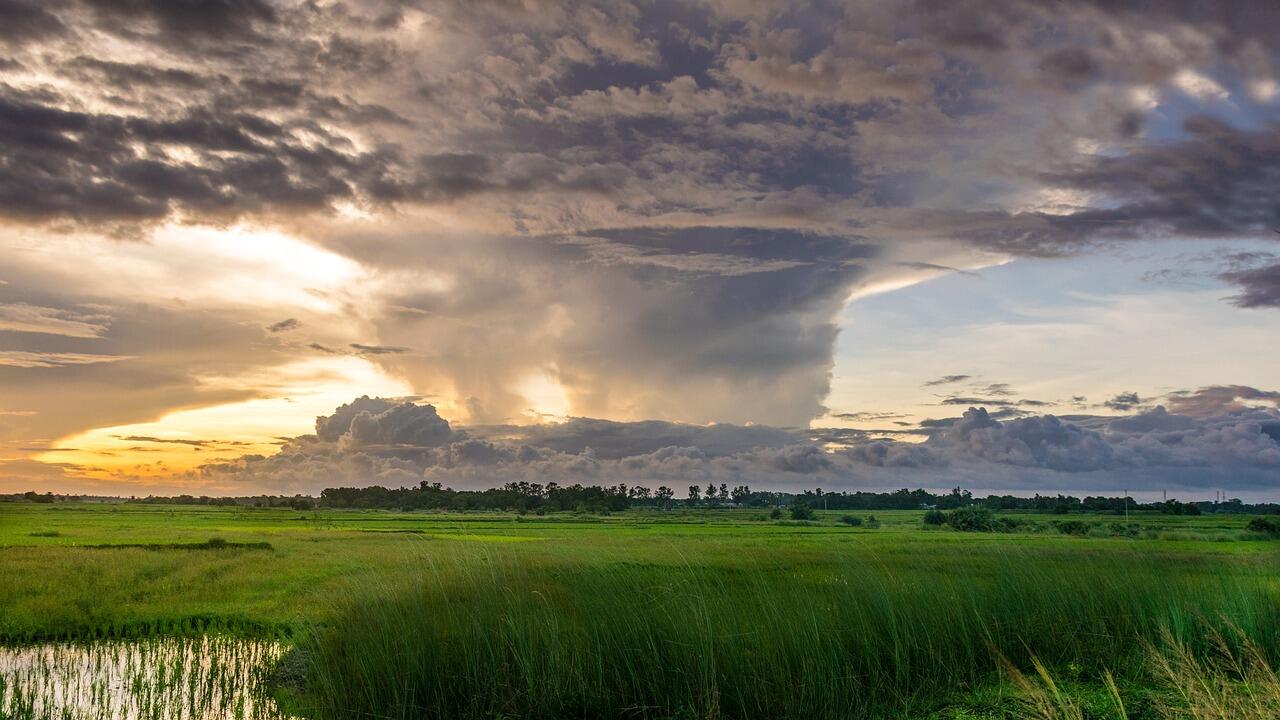 Imagem de uma tempestade em um campo no por do sol