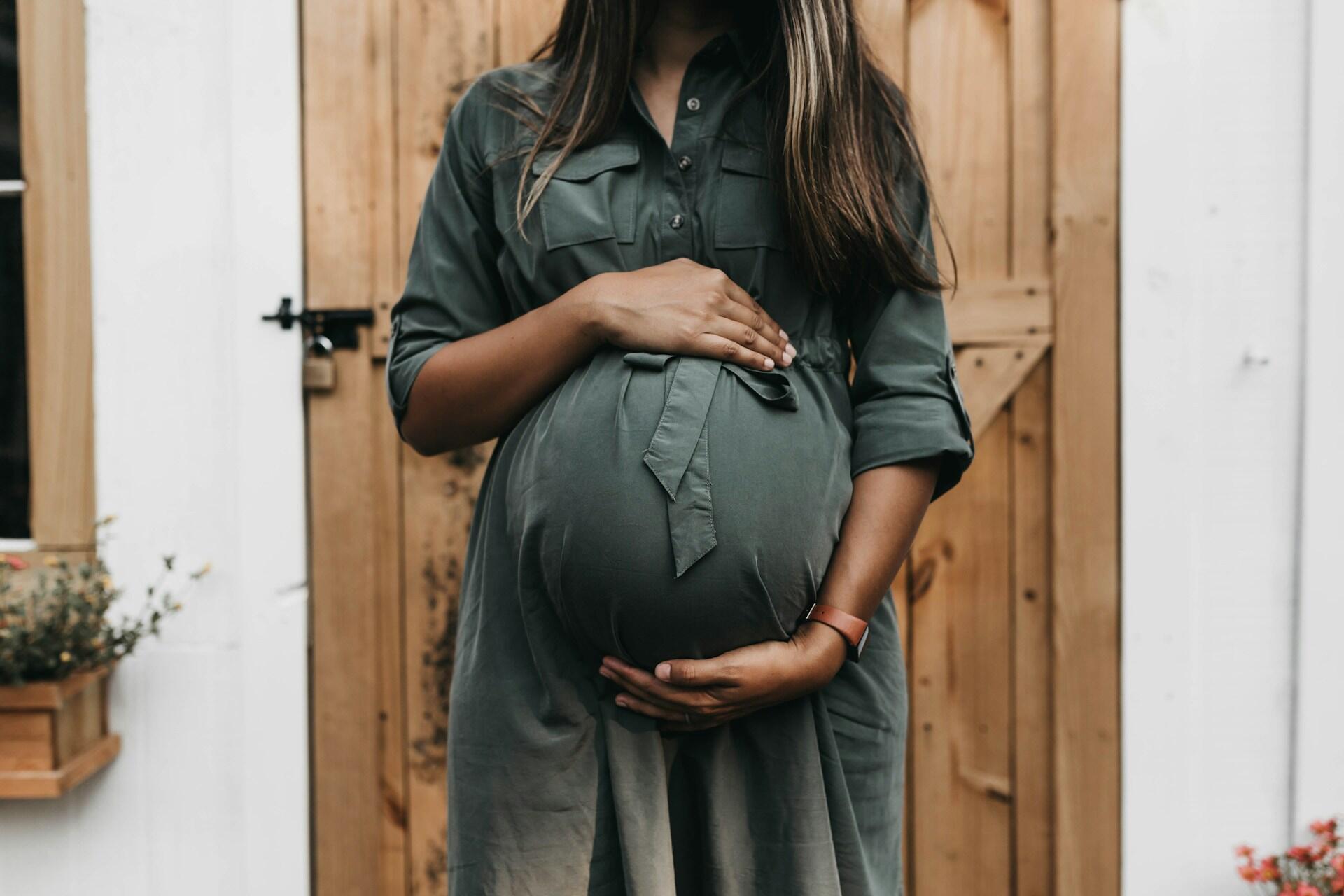 Imagem de uma mulher grávida segurando a barriga.