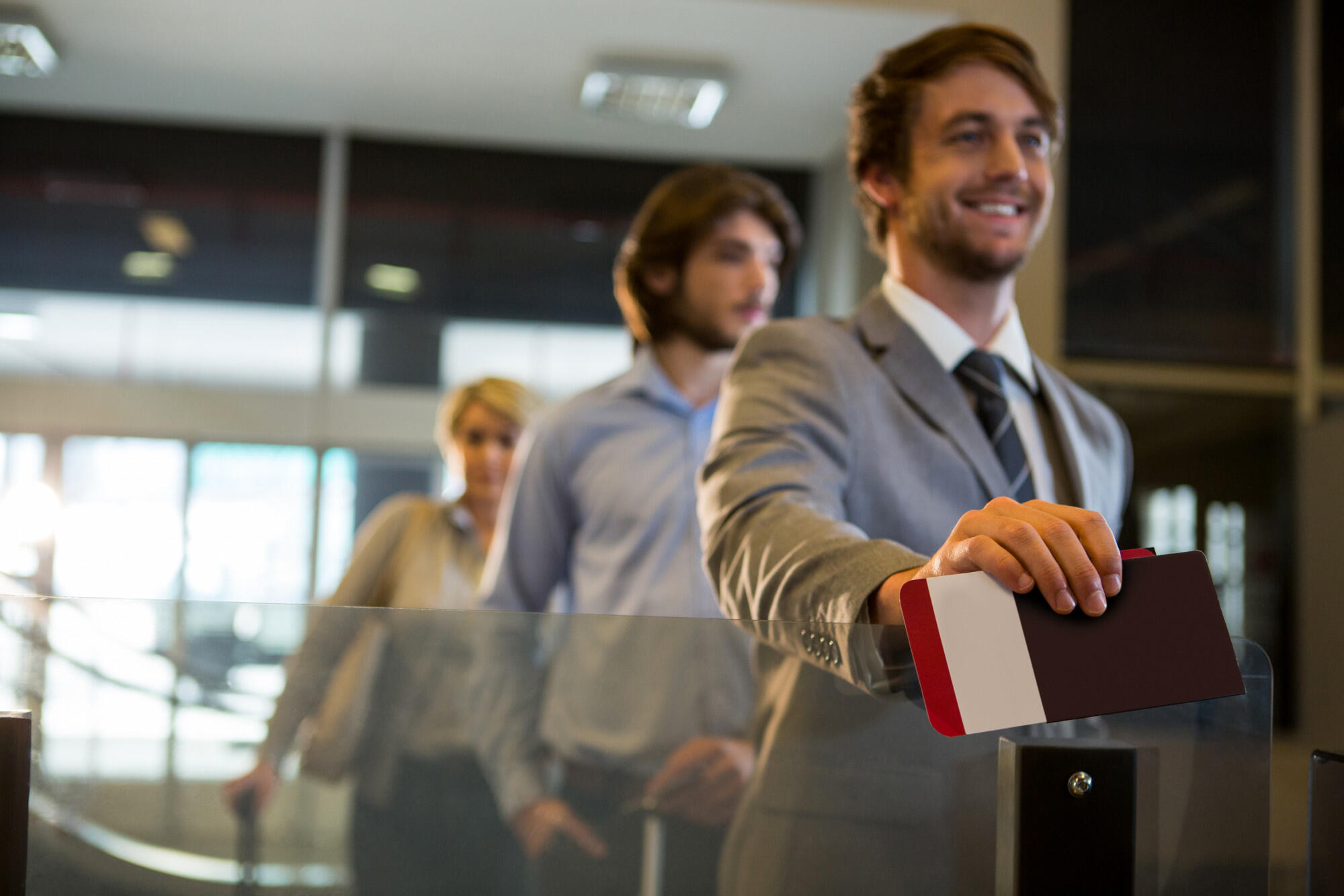 Pessoas sorridentes imigrando para o Brasil no aeroporto e mostrando o passaporte.