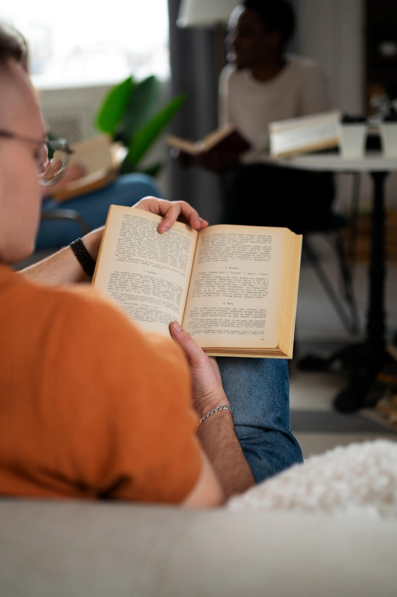 Homem sentado, lendo um livro.