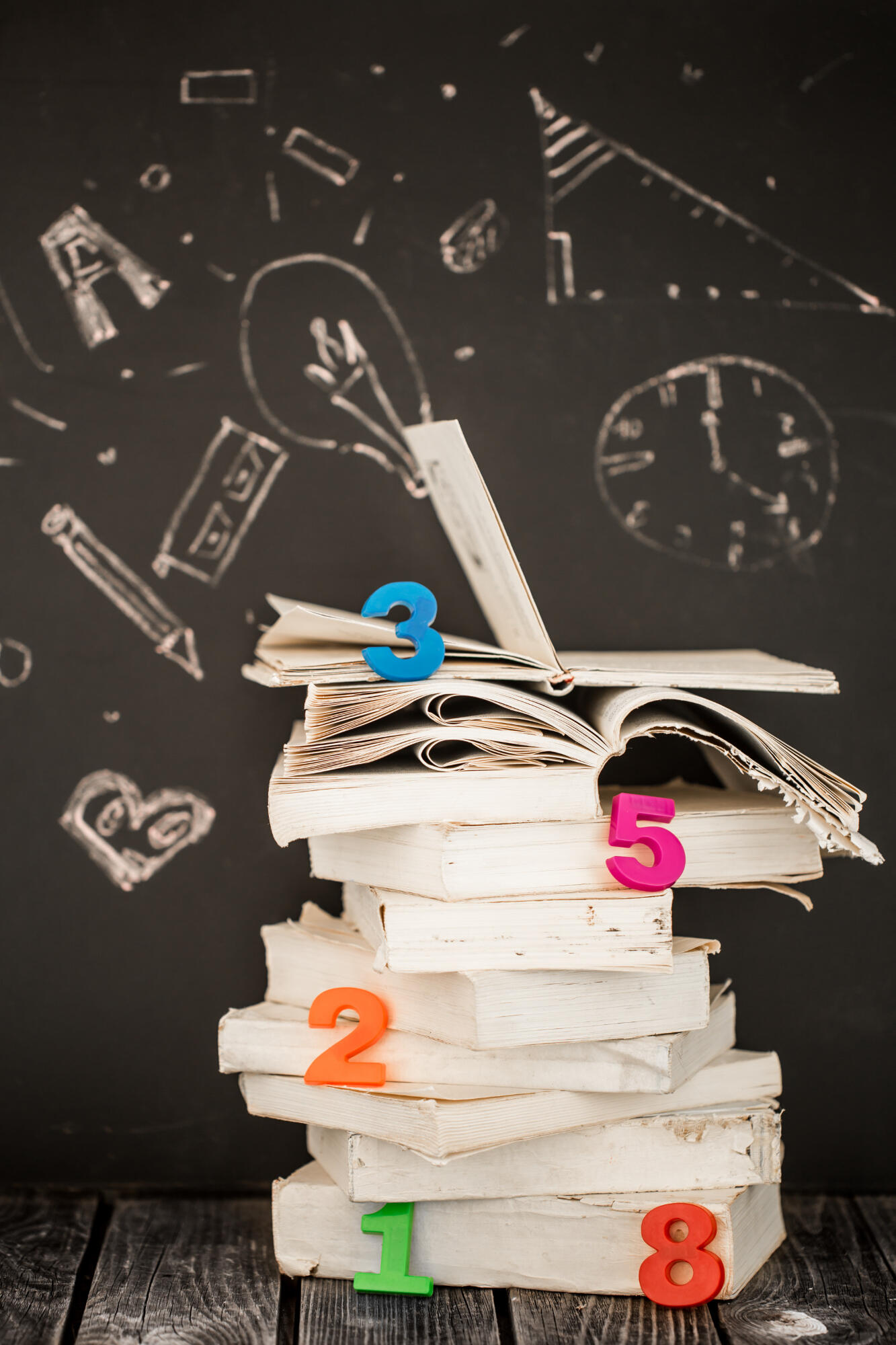 Livros e números de matemática na lousa.