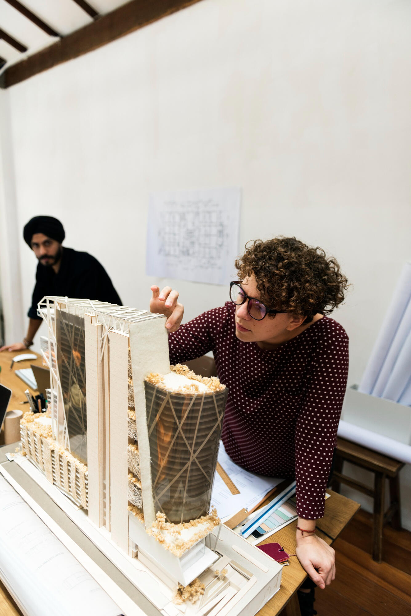Estudante de arquitetura montando prédio arquitetônico.
