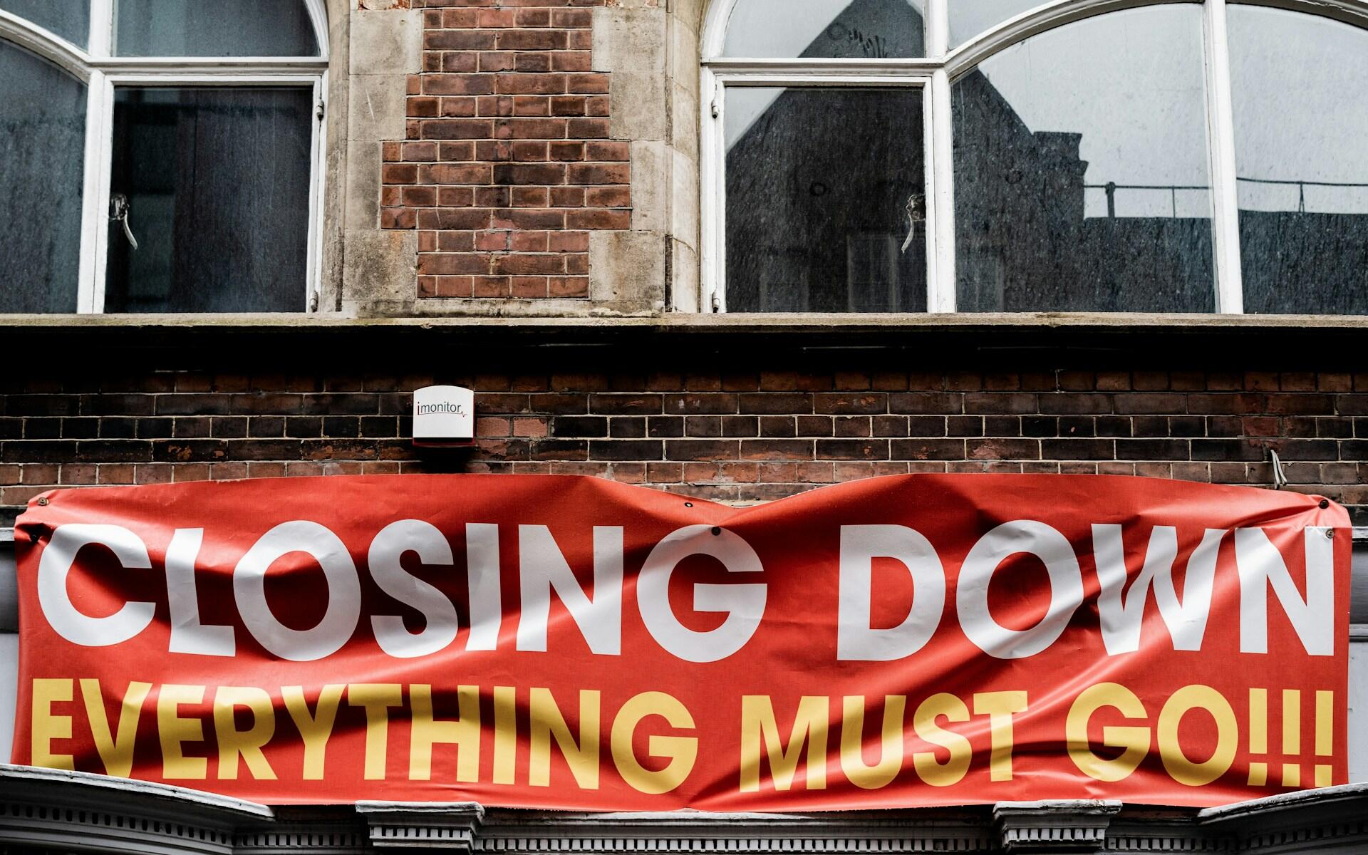 front of a store with a large banner hanging above the door that reads