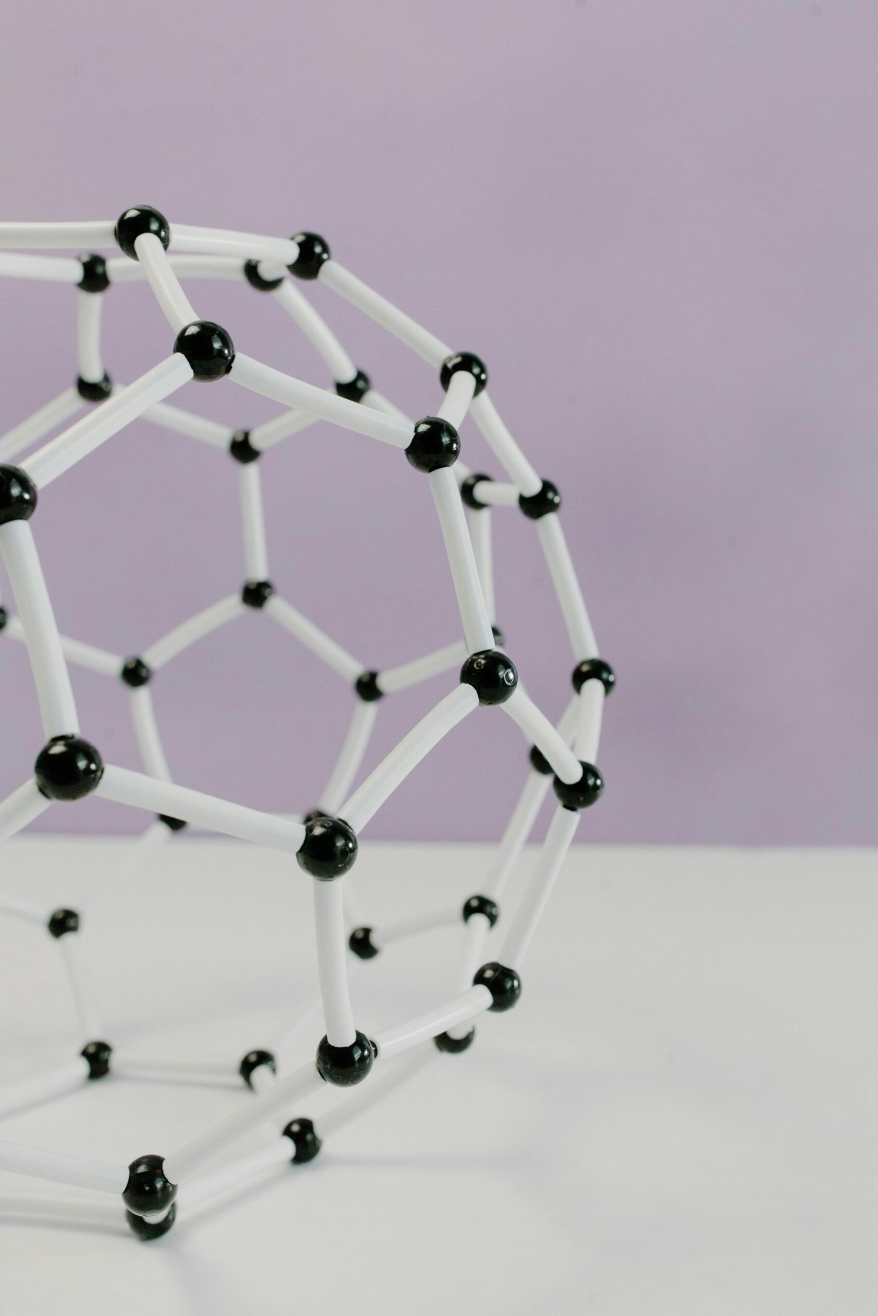 a black and white model of an atom with a purple background.