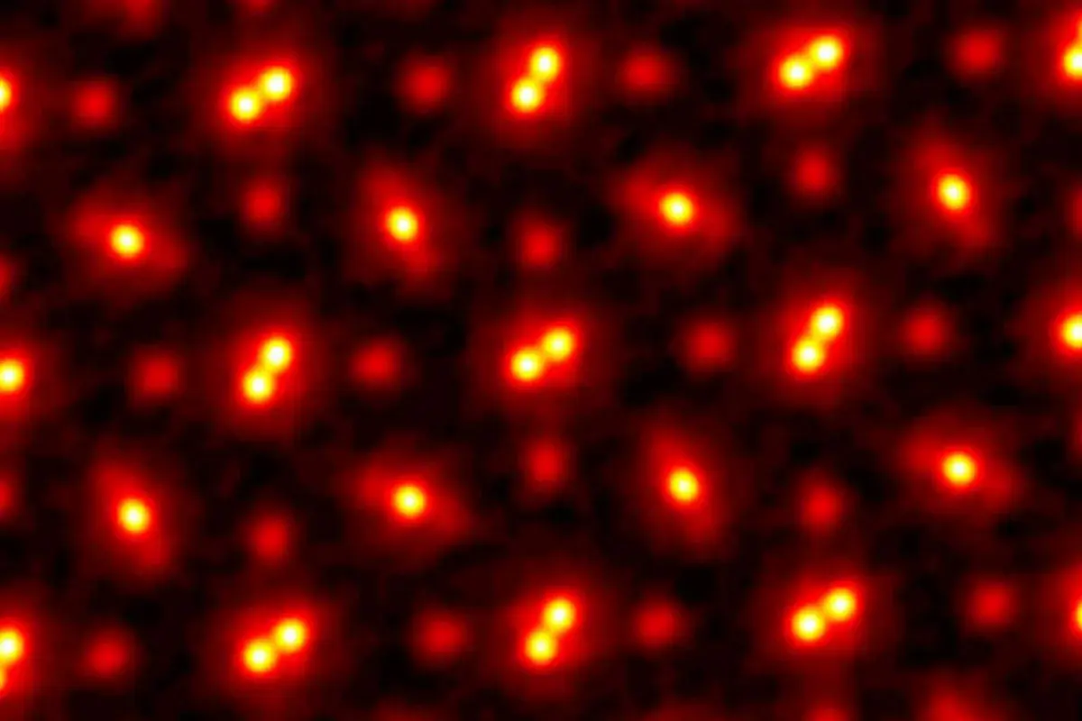 photo of atoms, showing nuclei as bright yellow circles with fuzzy red auras and other circles spread evenly throughout