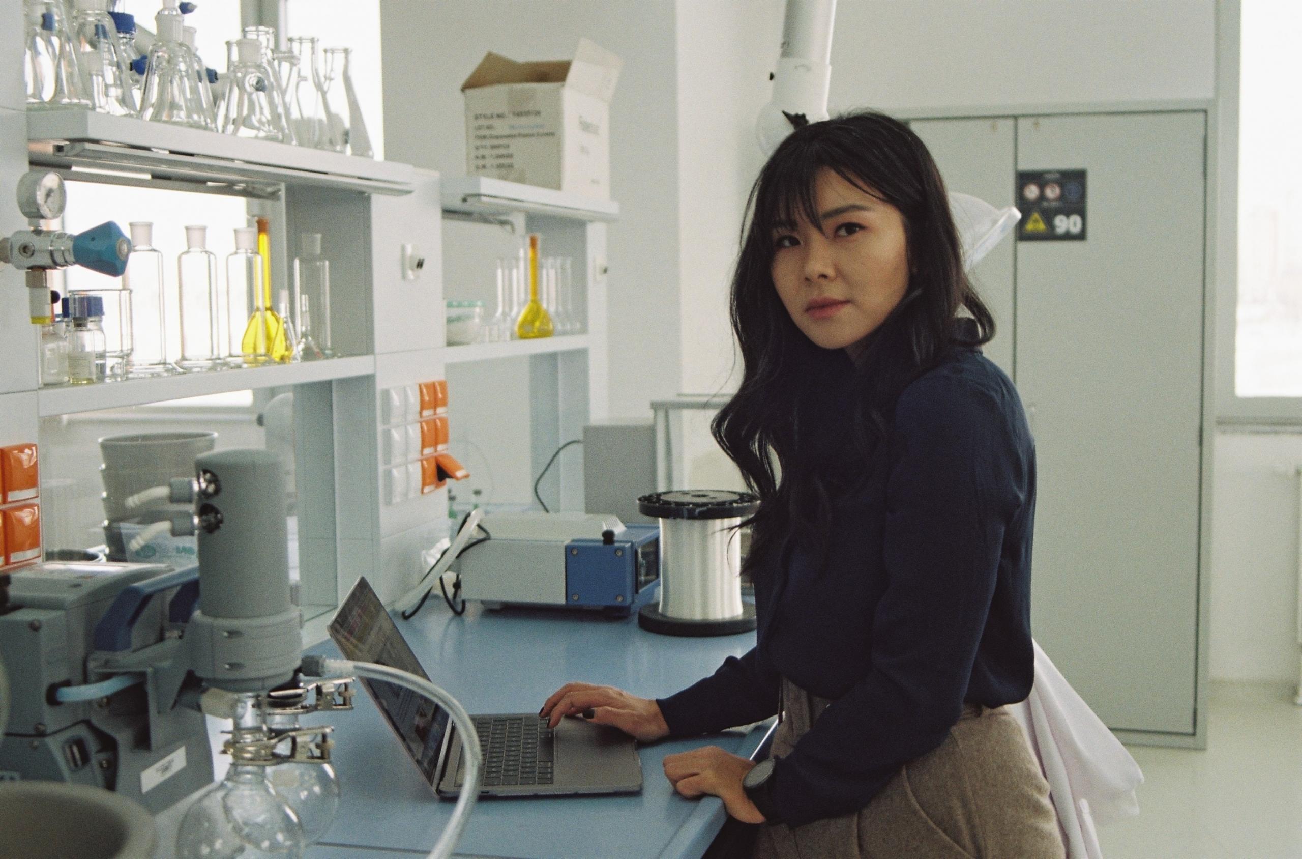 A woman stands in a laboratory.