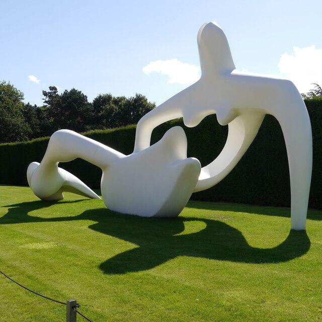 Henry Moore's abstract reclining figure sculpture displayed in an outdoor garden.