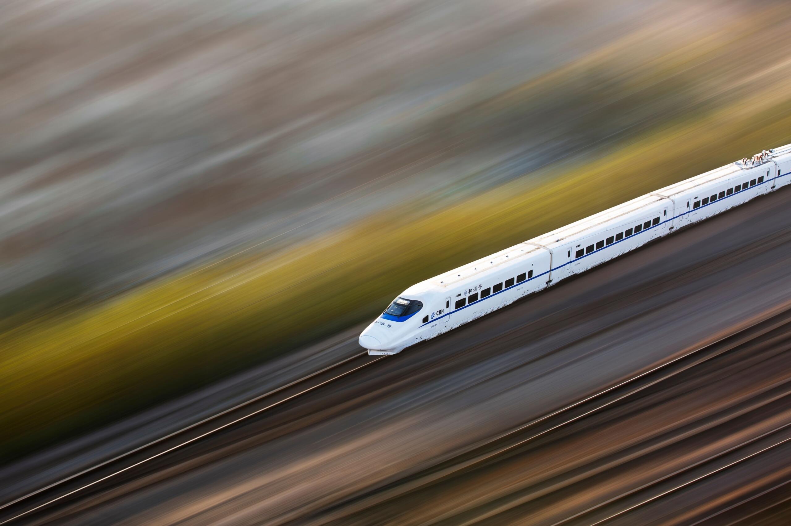 A high-speed maglev train travelling along an elevated track, using magnetic forces to levitate and move above the guideway with minimal friction.