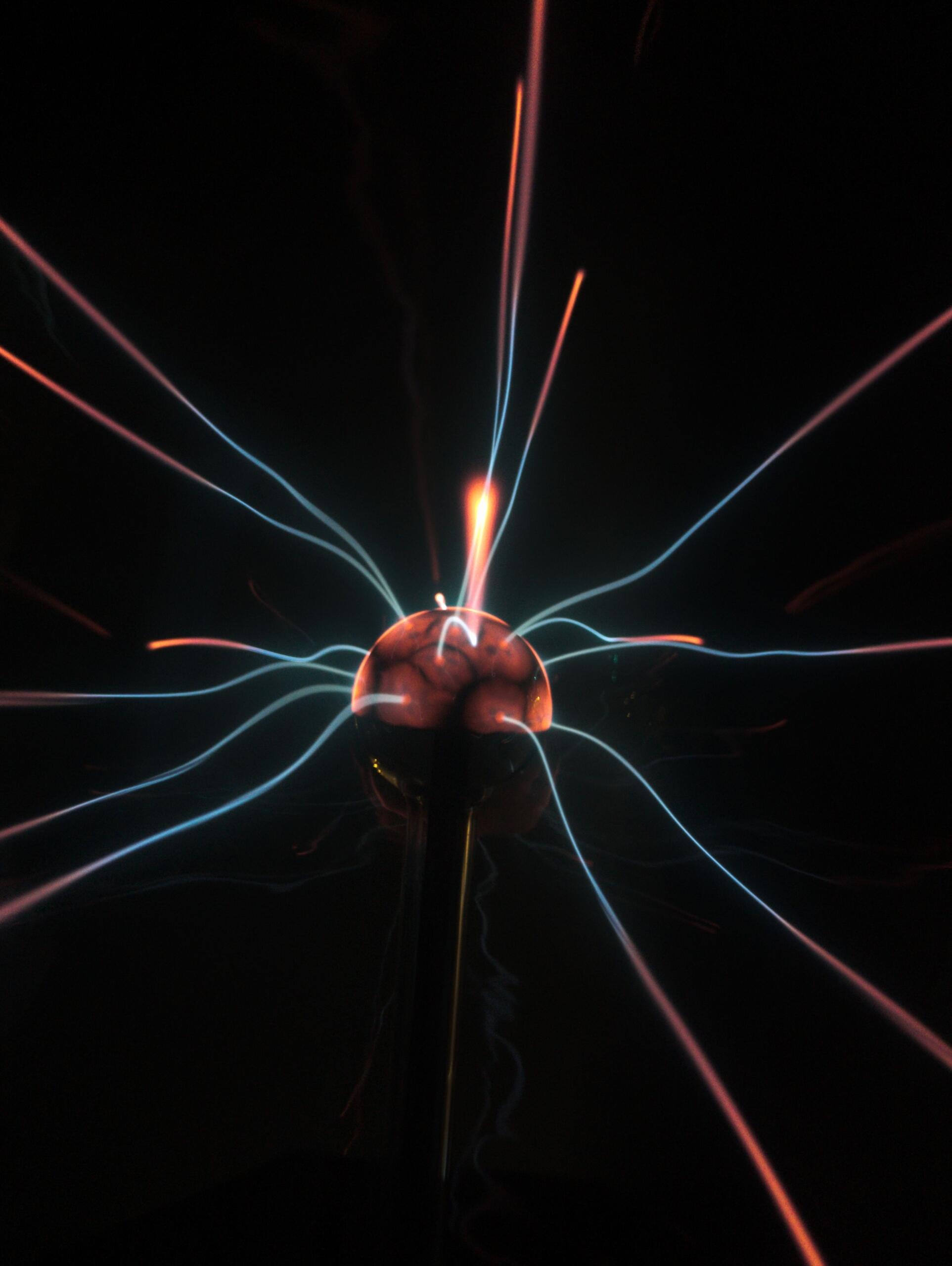 Illustration of electric currents flowing around a glowing orb, representing the relationship between moving electric charges and magnetic fields.
