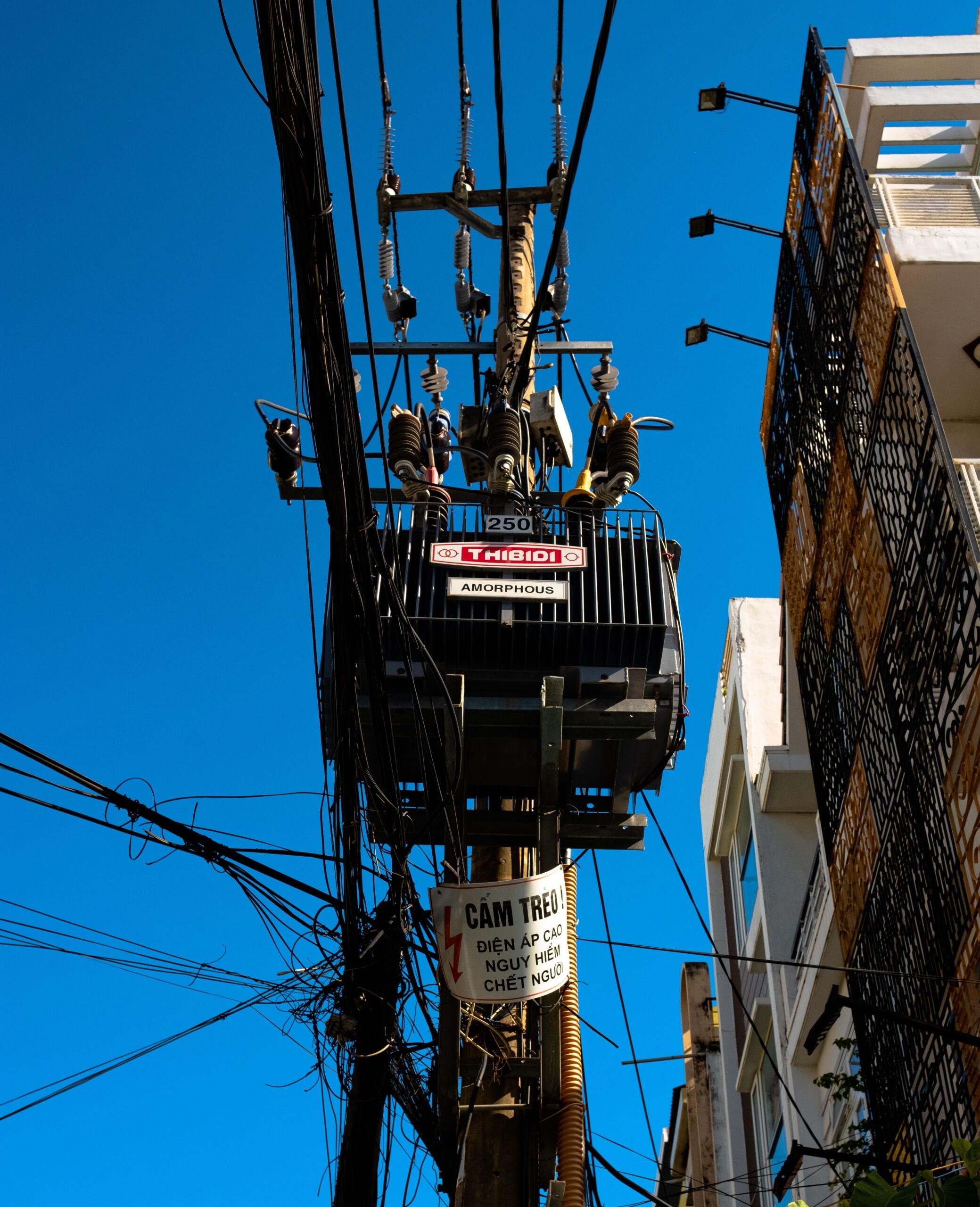 An electrical transformer with large coils and insulated components used to transfer electrical energy and change voltage levels.