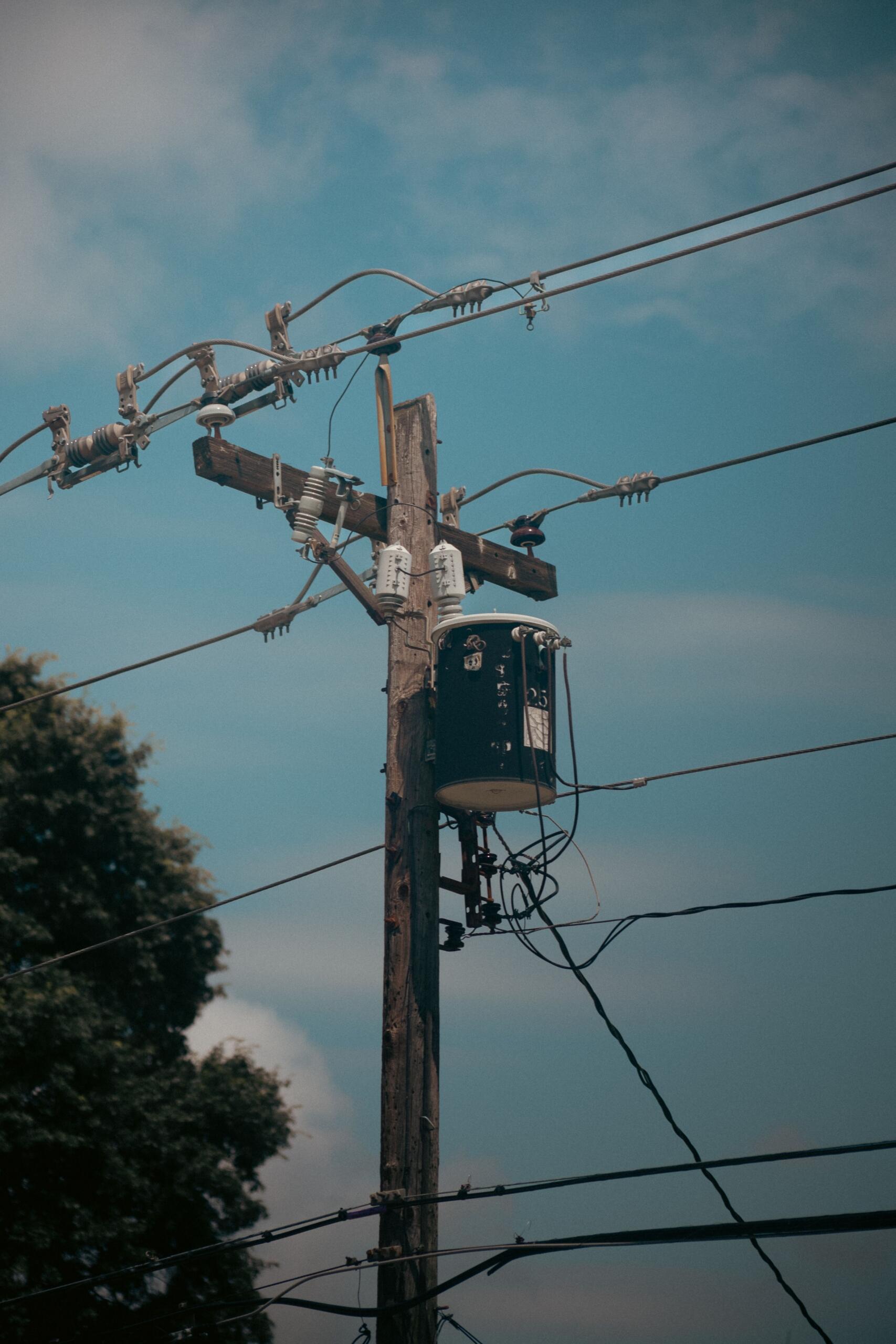 An electrical transformer with large coils and insulated components used to transfer electrical energy and change voltage levels through electromagnetic induction.