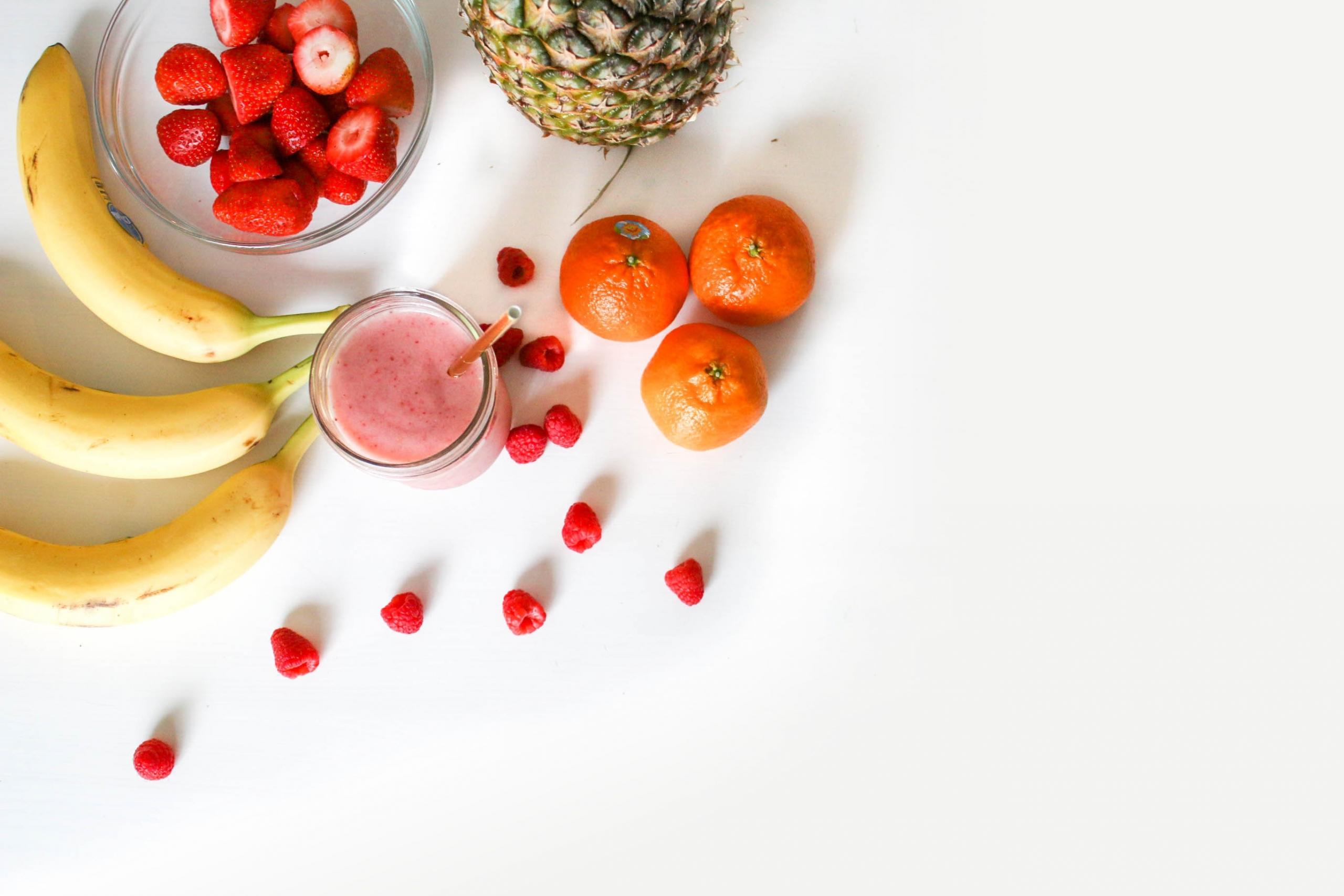 a table covered in fruit and a smoothie