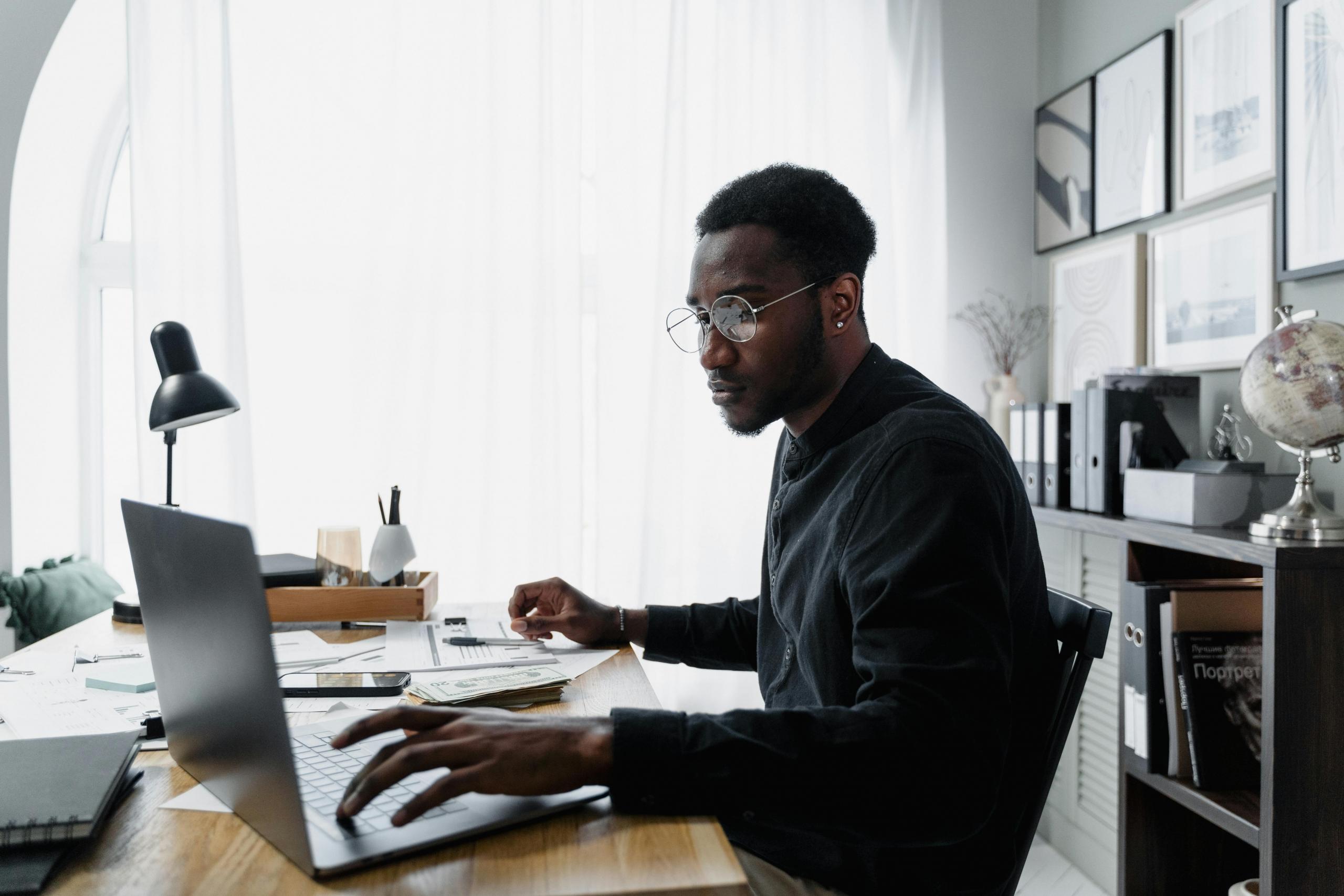 Man sitting at a desk going over his expenses and income for the year.