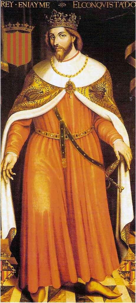 Medieval portrait of James I of Aragon (James the Conqueror) wearing a gold crown, ornate robes, and a ceremonial cloak. He stands holding a sword beside the striped coat of arms of the Crown of Aragon, symbolizing his role in the expansion of the kingdom during the 13th century.