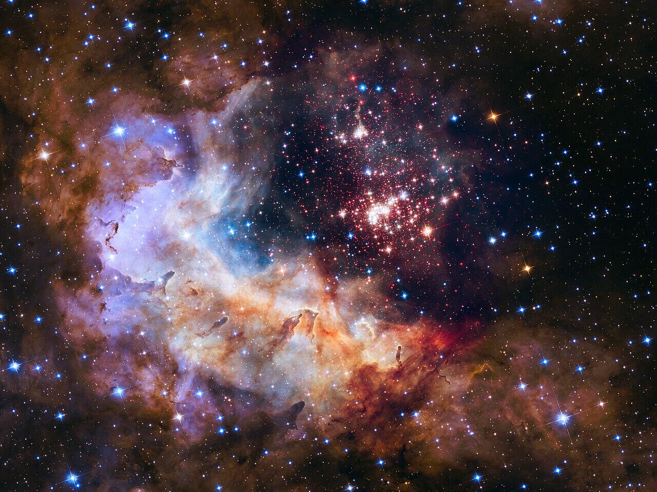 photo taken with the Hubble Telescope of a dense group of stars among a nebula in space