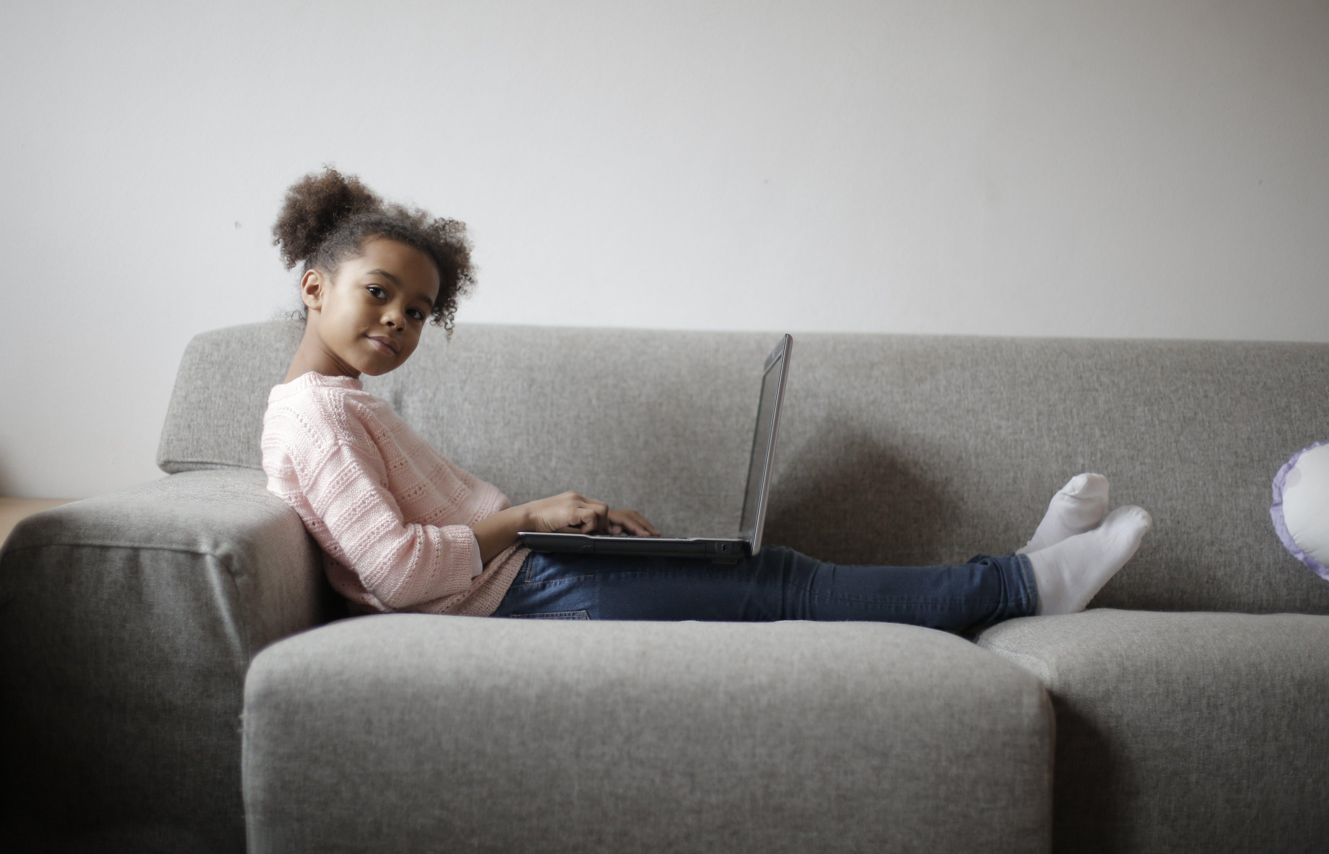 a child works on her computer at home