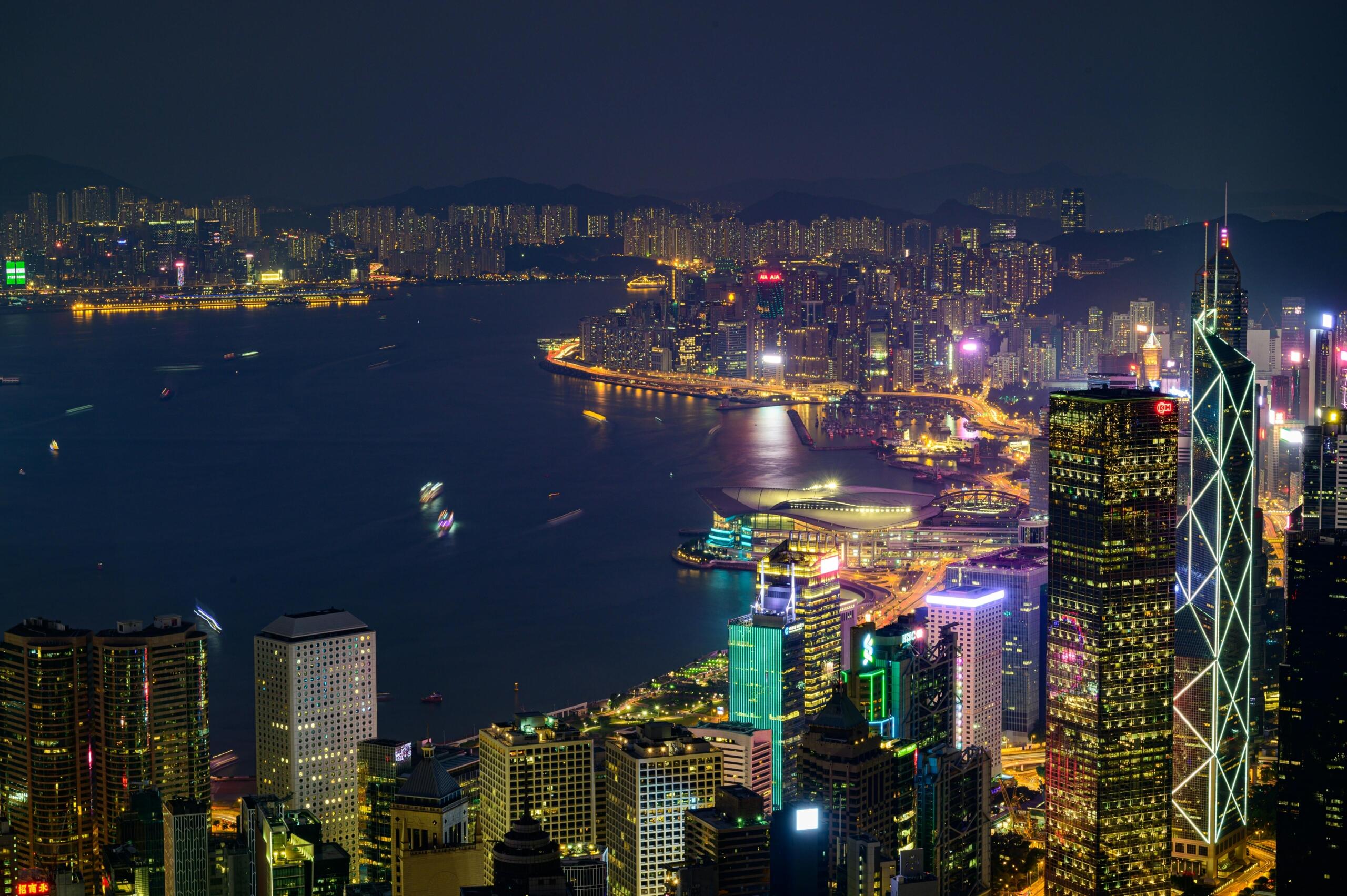 The Hong Kong skyline of tall buildings at night.