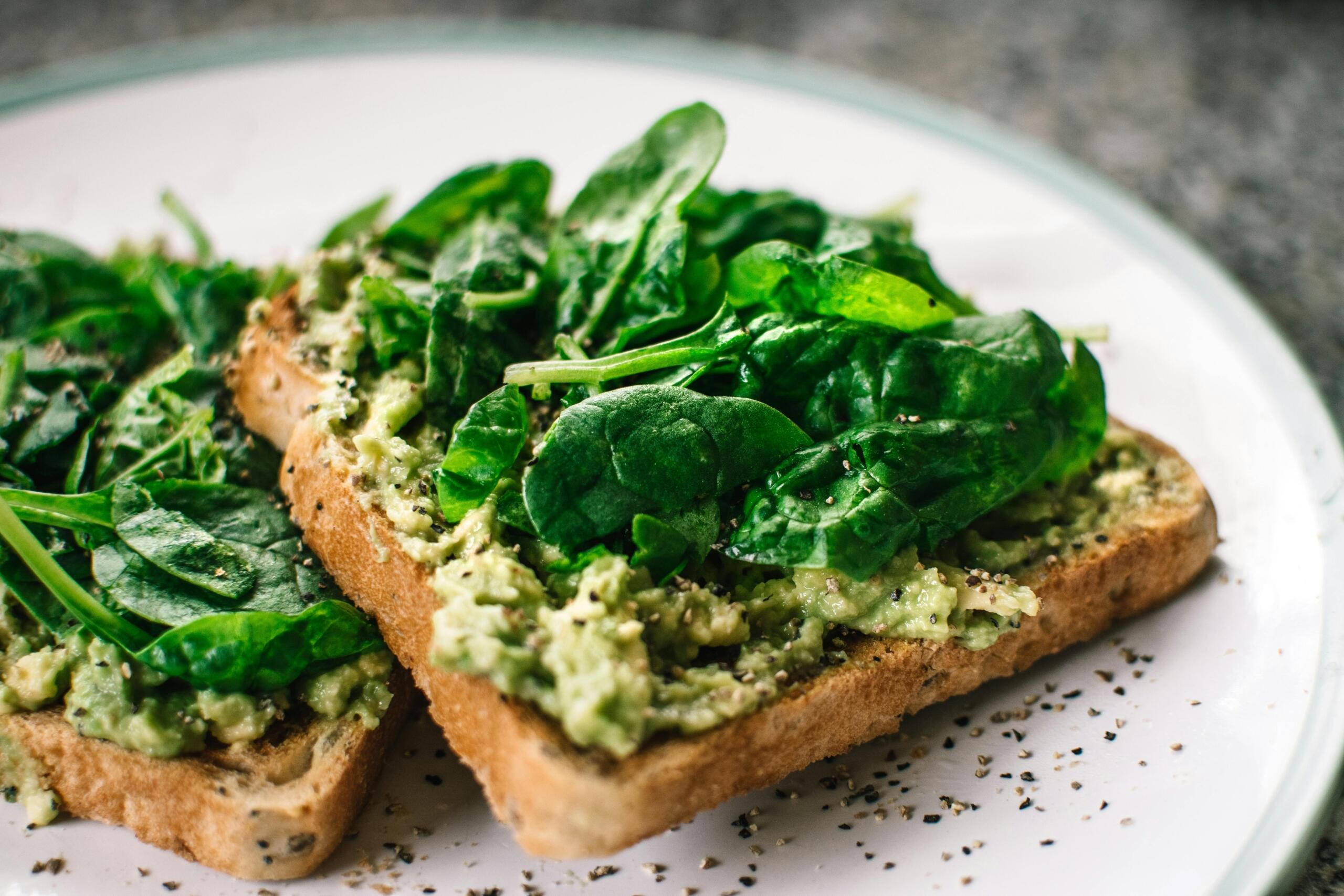 toast covered in mashed avocado and spinach.