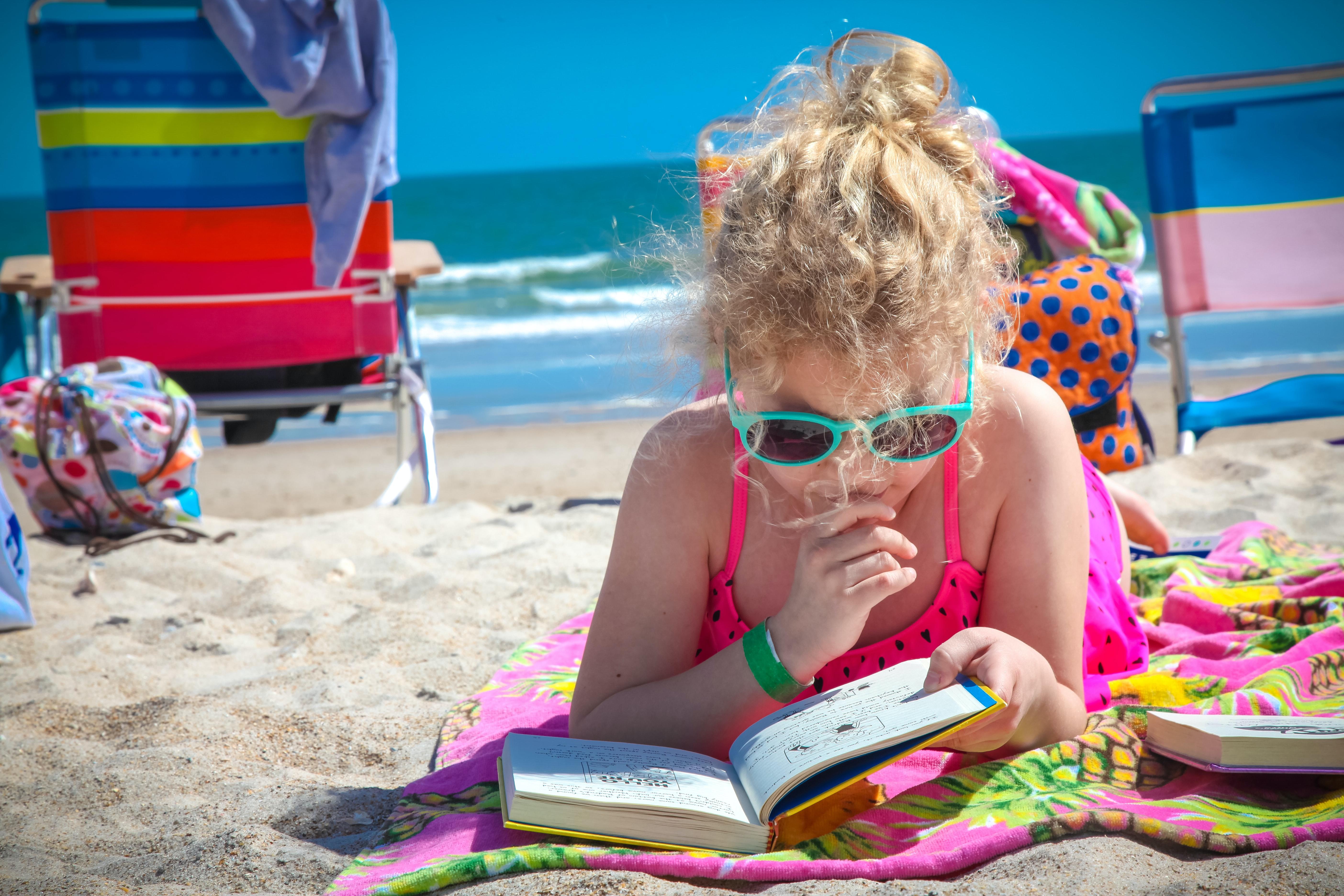 a child reads at the beach