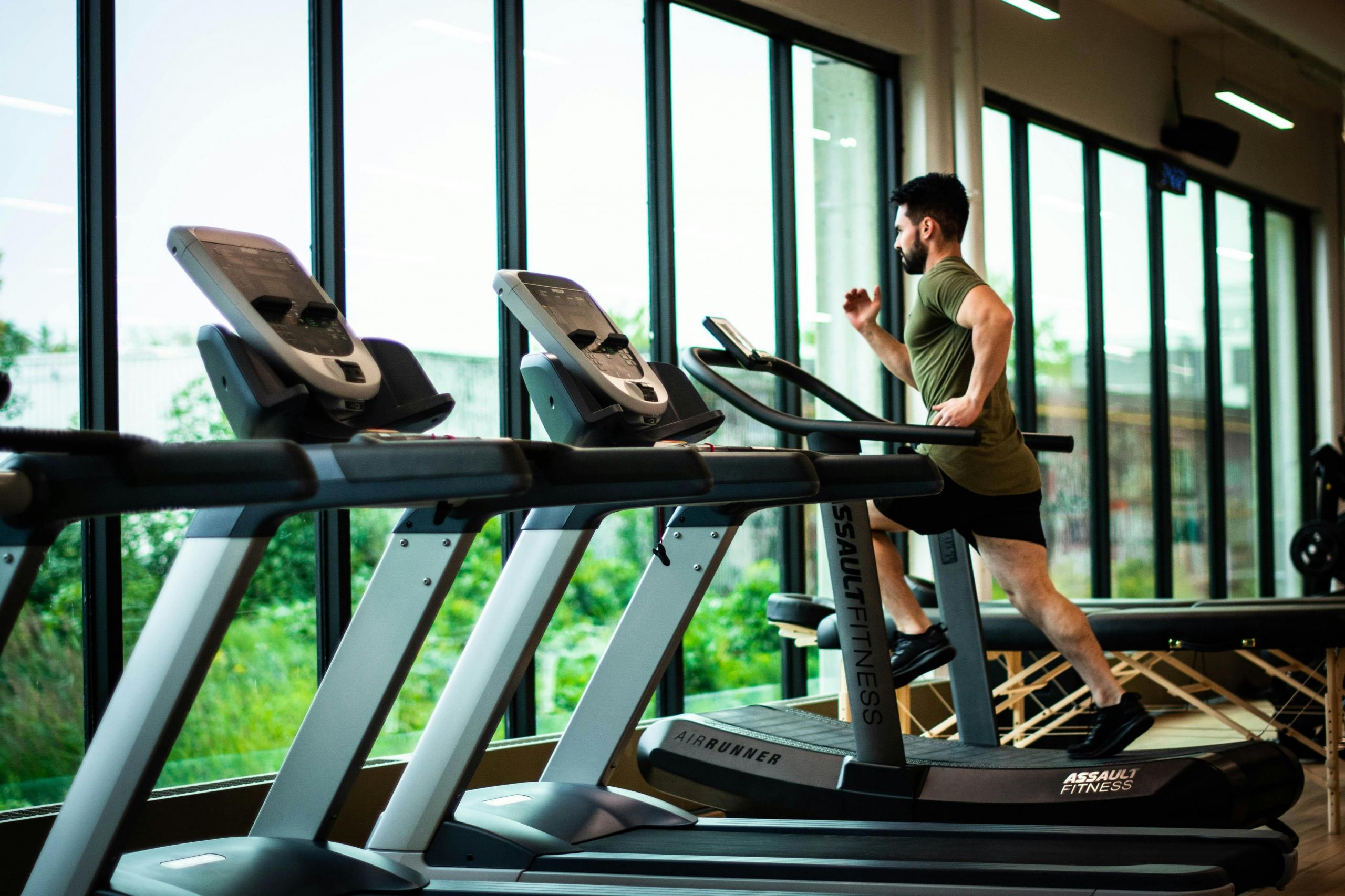 A man at the gym running  on the treadmill. 