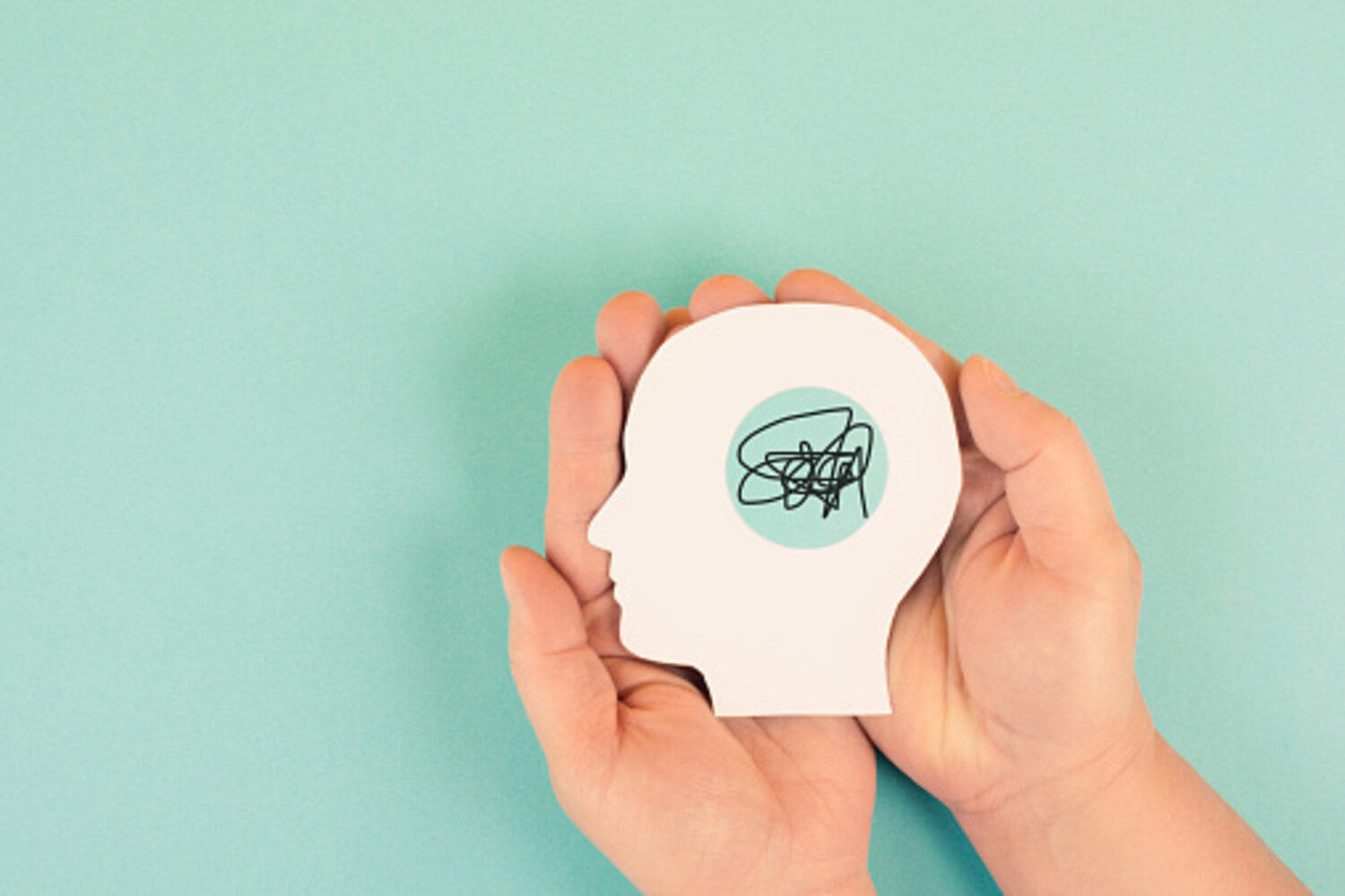 Hands holding a silhouette of human head a