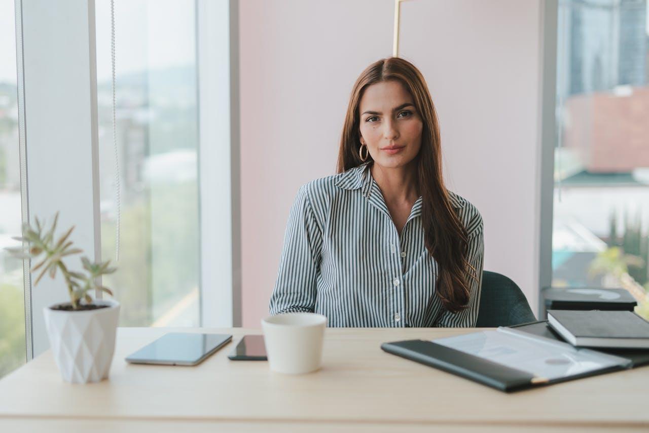 A business lawyer sitting at her desk with a plant and coffee cup.