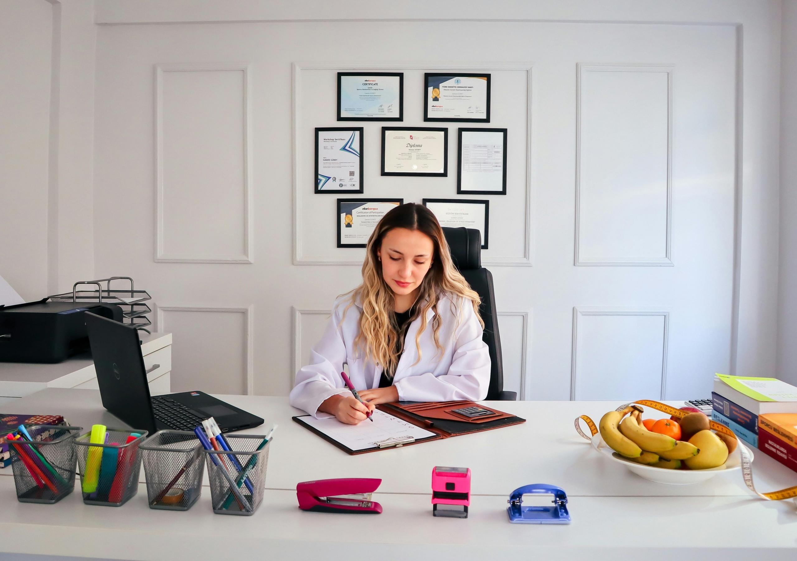 A Chief Clinical Dietitian in her office doing paperwork at the desk. 