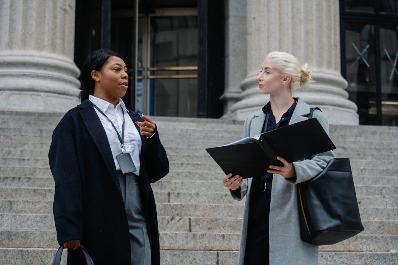 Two criminal lawyers talking about a case outside the courthouse.