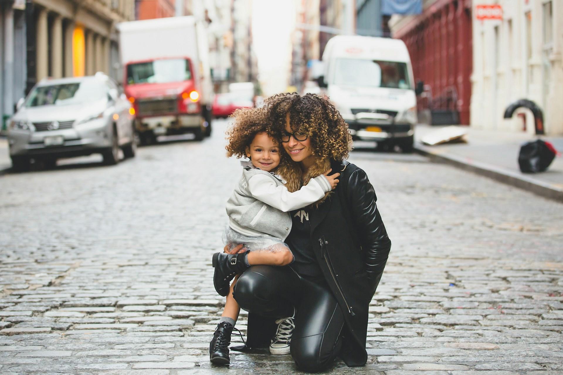 A mom and child in the street posing for a photo