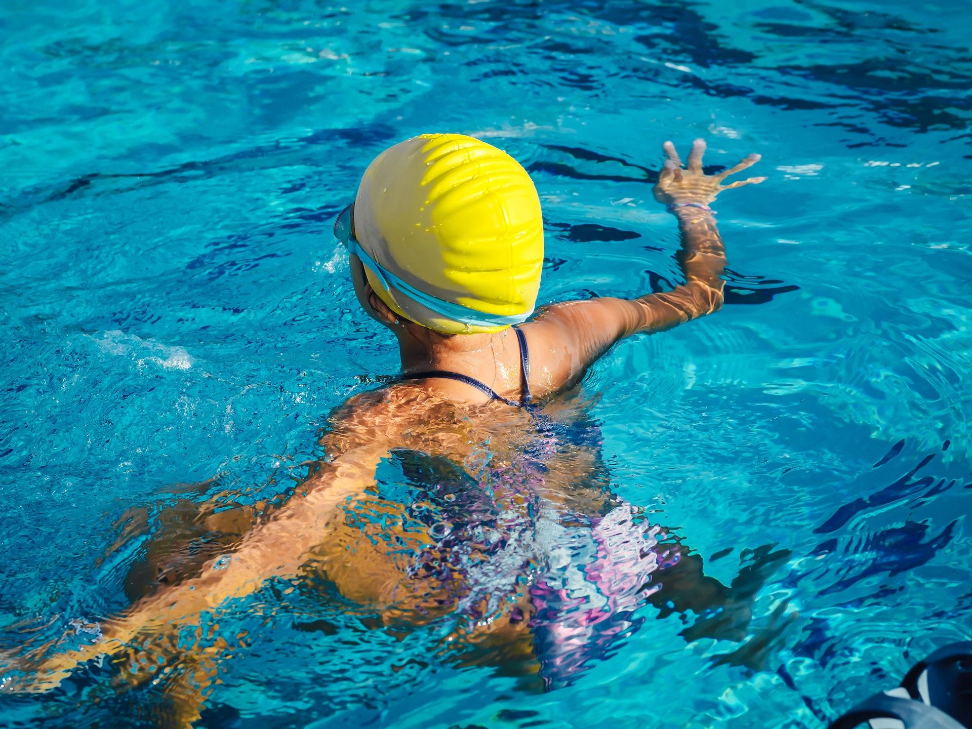 child swimming in indoor pool