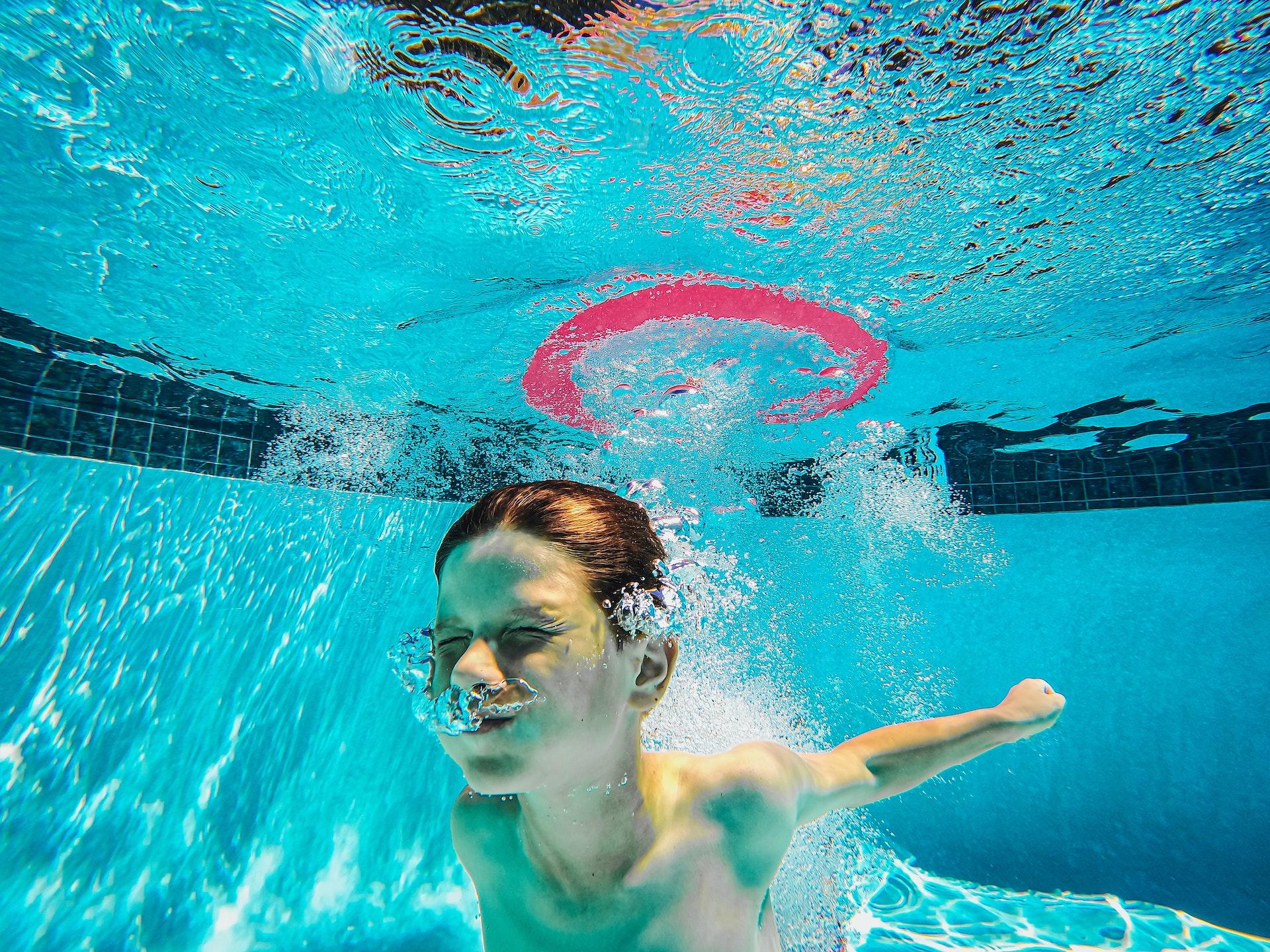 Young boy underwater swimming pool