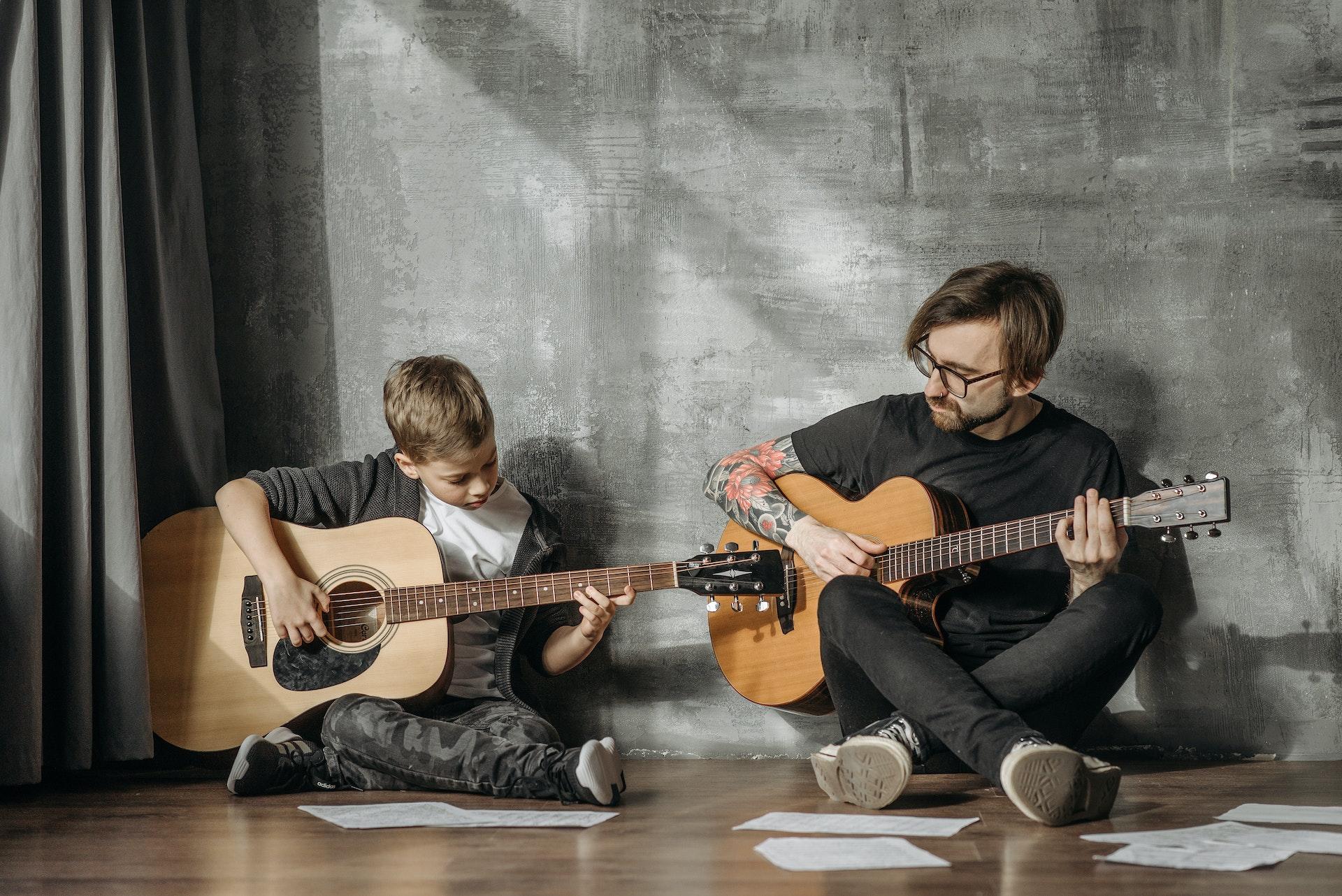 child learns guitar with teacher