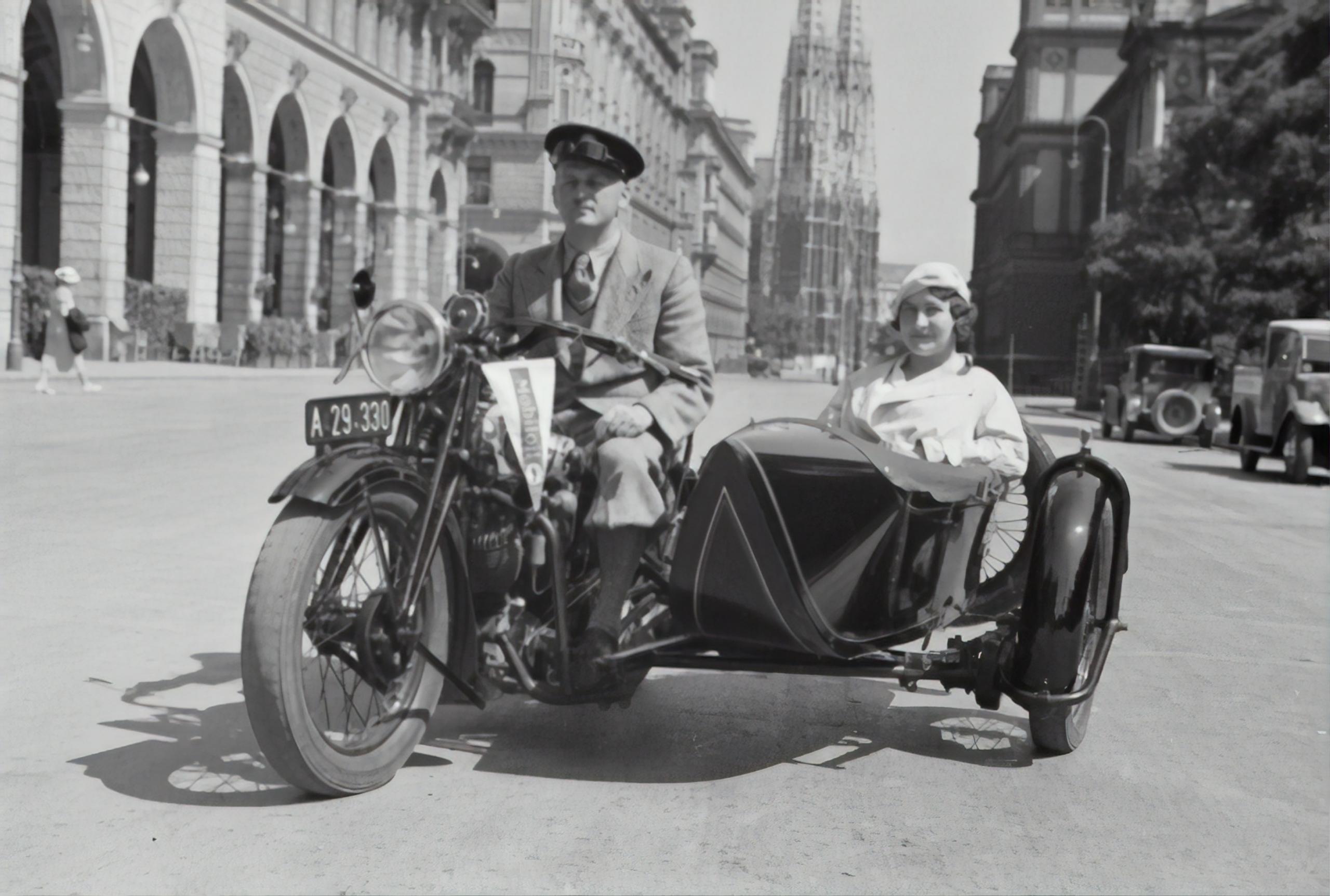 An old photo in Europe with a man on a motorcycle.