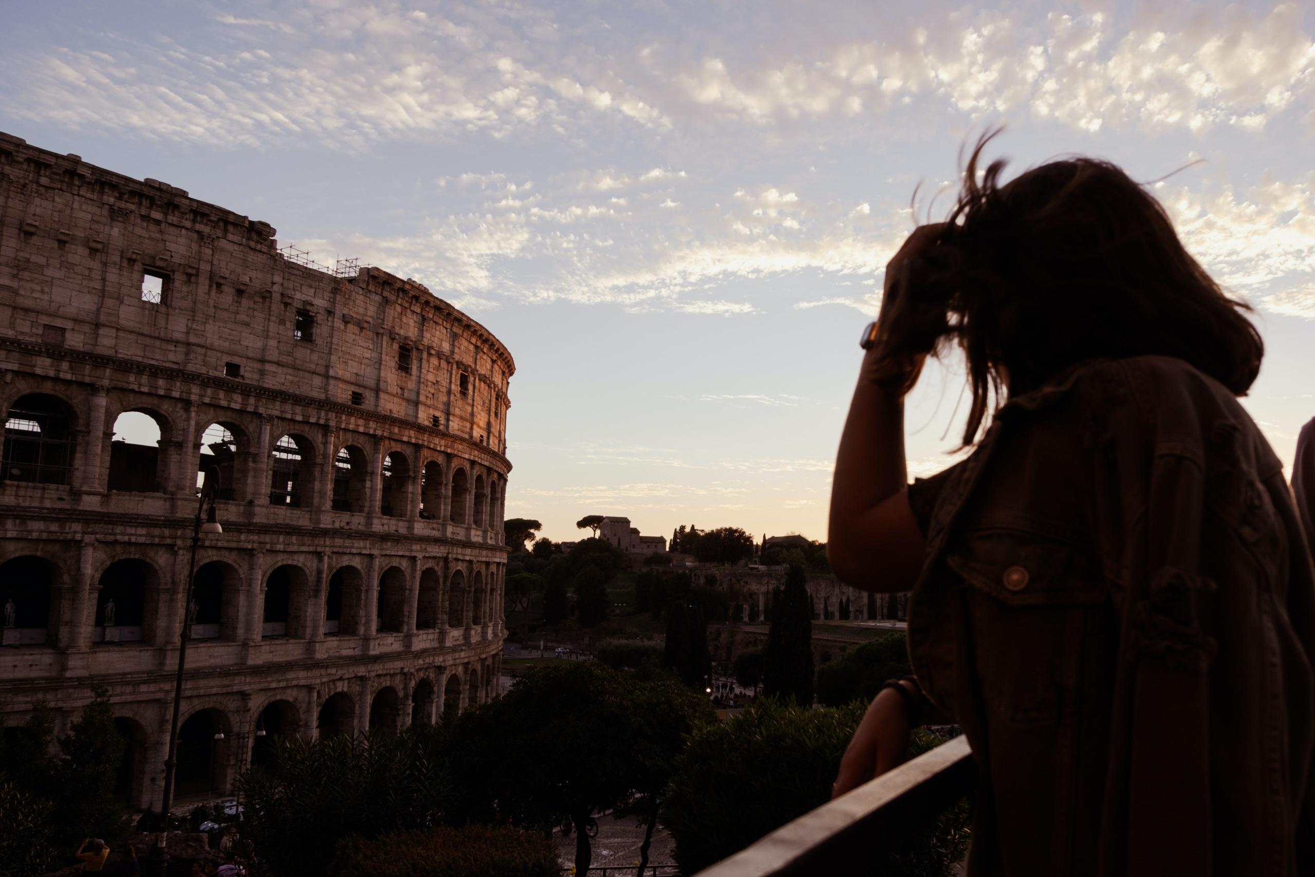 A woman looks at the colosseum in Rome.