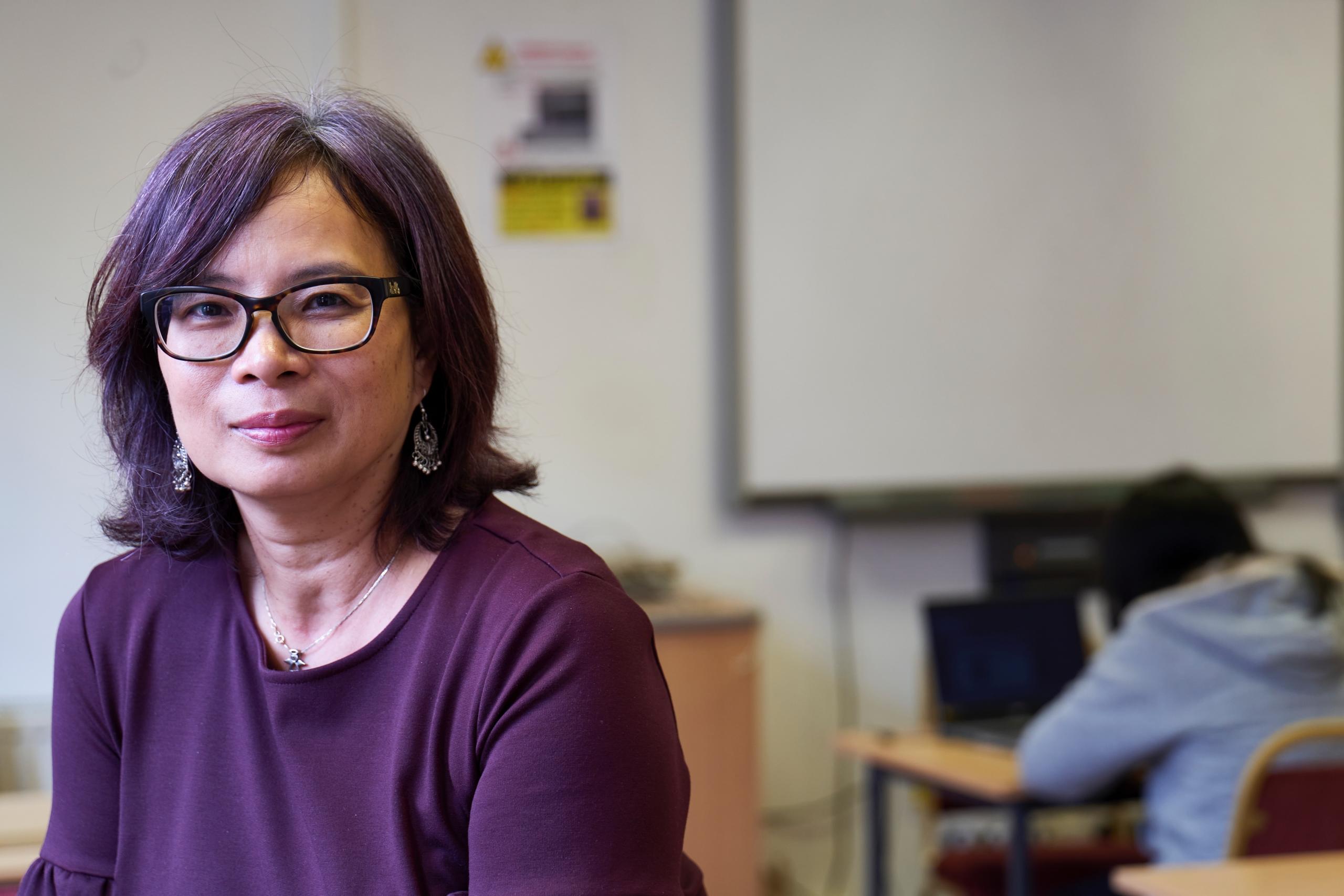 An experienced teacher sits in a classroom.