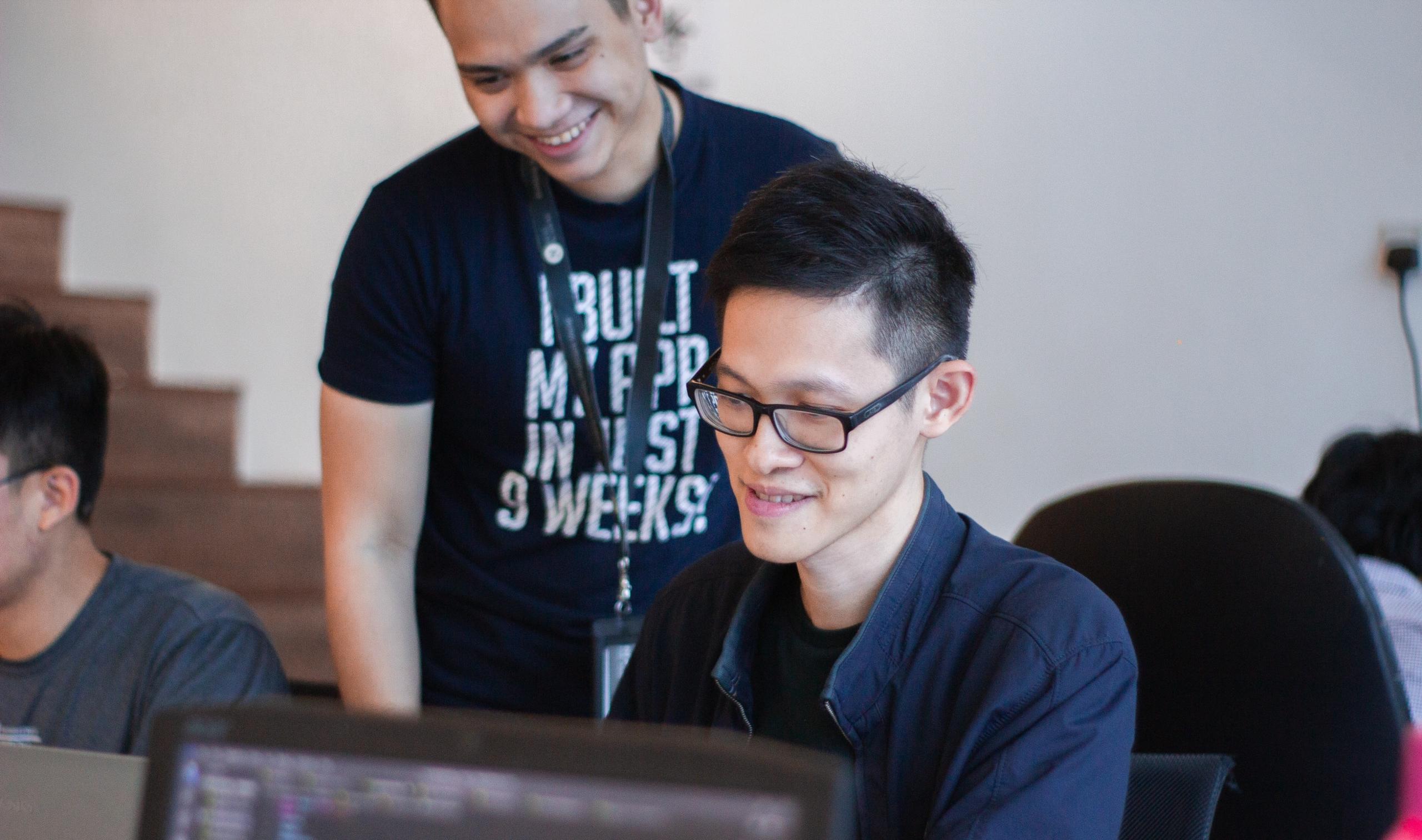 two professionals work in front of a computer in SQL.
