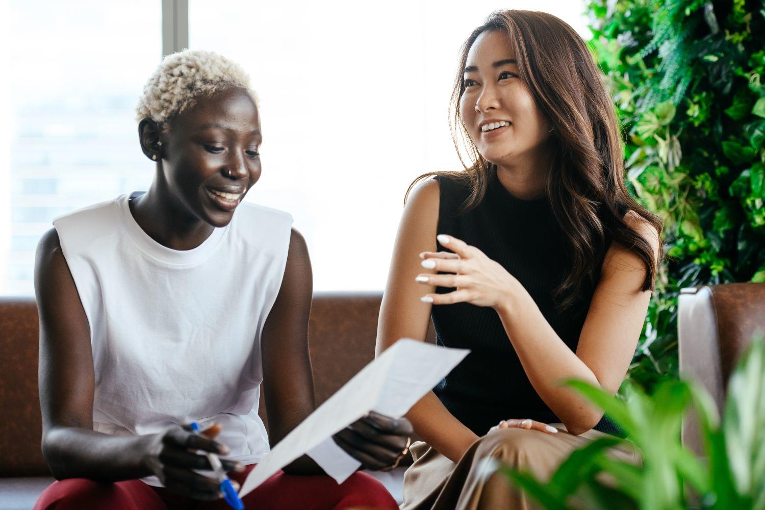 Two women laughing and learning piano